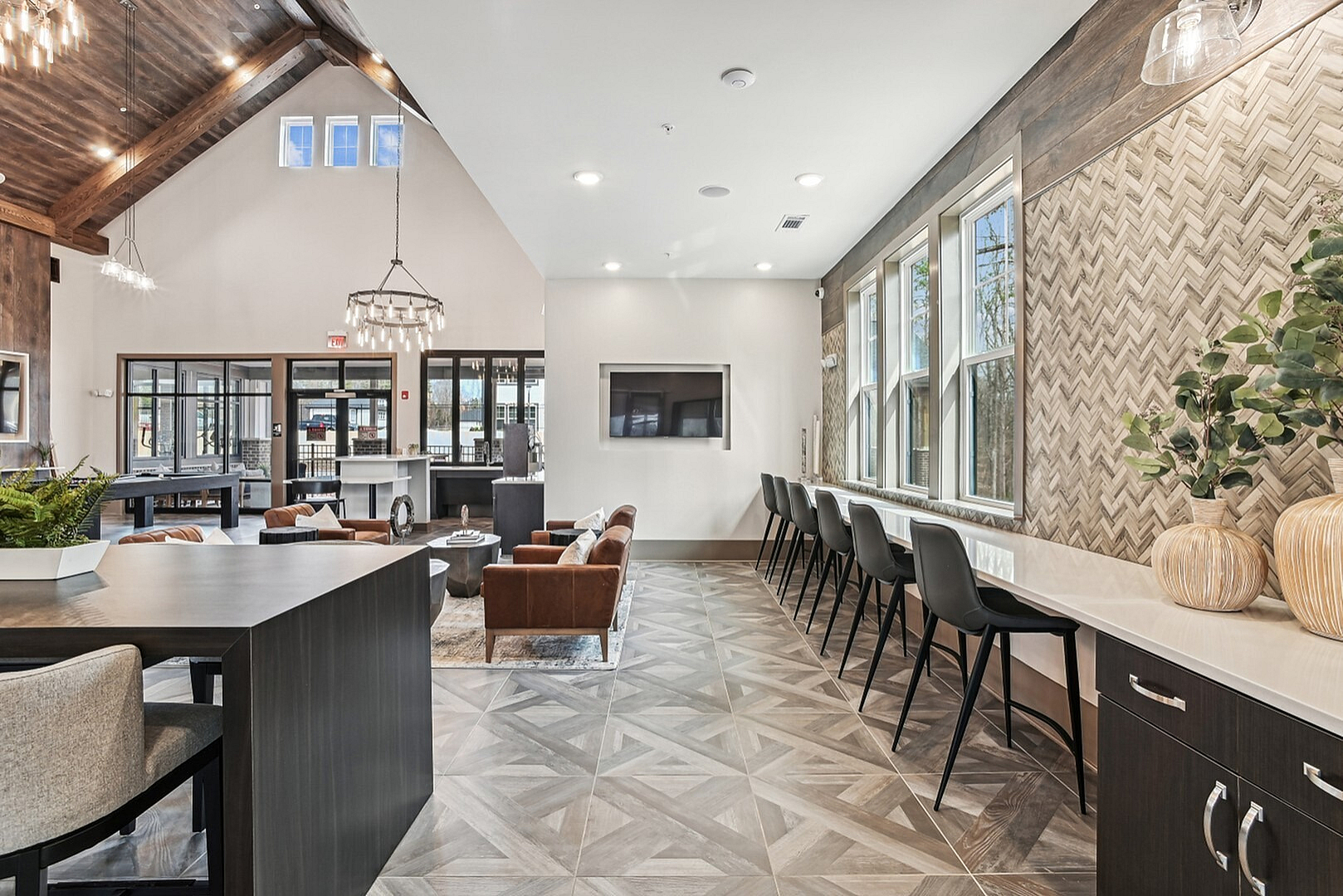 Modern, spacious communal area featuring elegant high ceilings, stylish seating, and ample natural light from large windows.