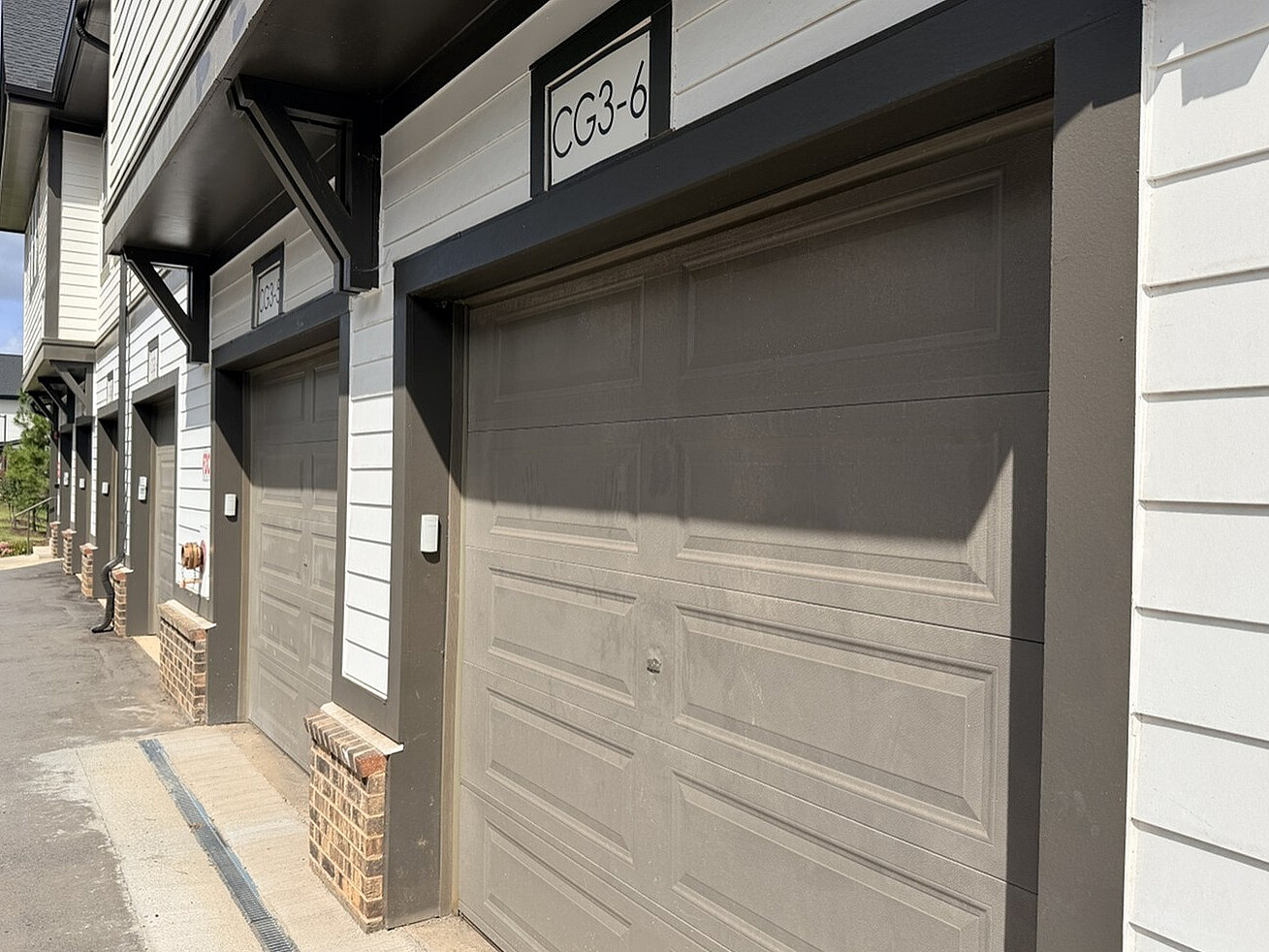 Charming row of modern garages with sleek wood paneling, offering ample parking in a well-maintained community setting.