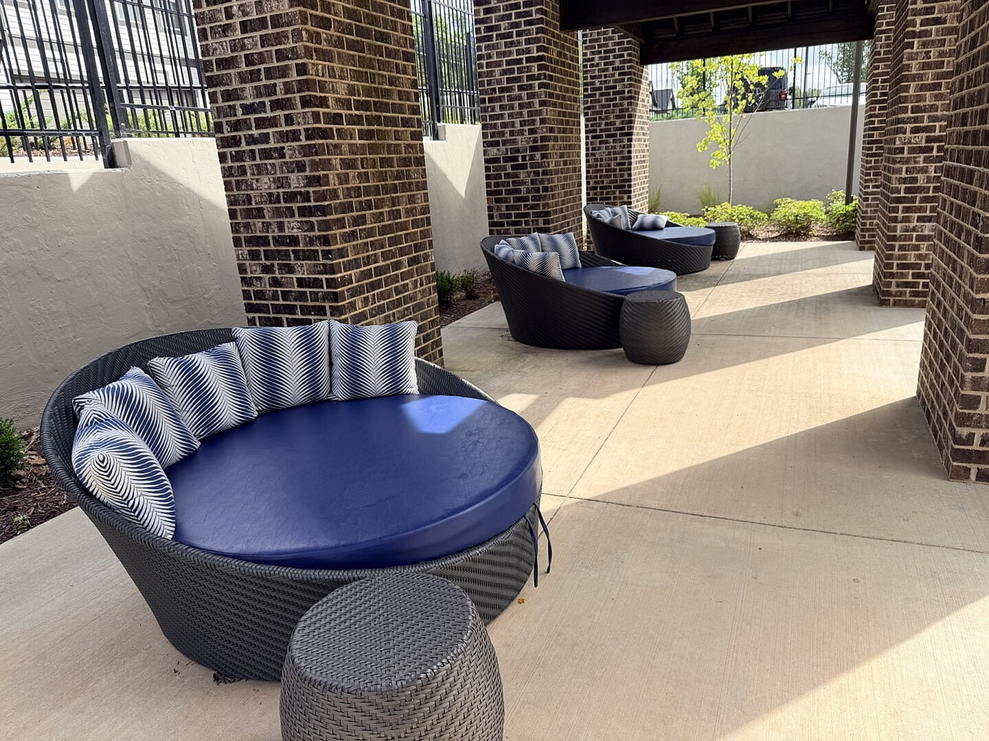 Chic outdoor seating area with cozy round wicker chairs and plush cushions, perfect for relaxing in style.
