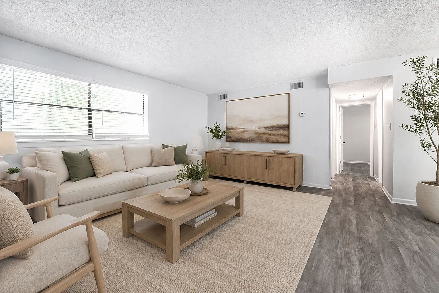 Inviting living room with a plush beige sofa, modern decor, and abundant natural light, perfect for relaxation.