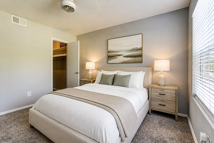 Inviting bedroom with a plush bed, elegant decor, and abundant natural light through large windows.
