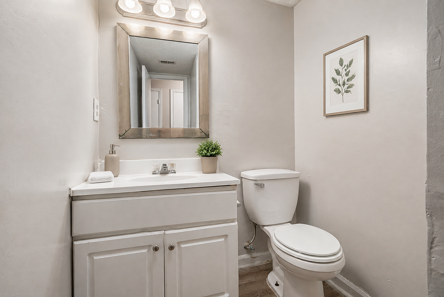 Elegant bathroom featuring a modern vanity, stylish mirror, and tasteful botanical artwork, creating a serene and functional space.