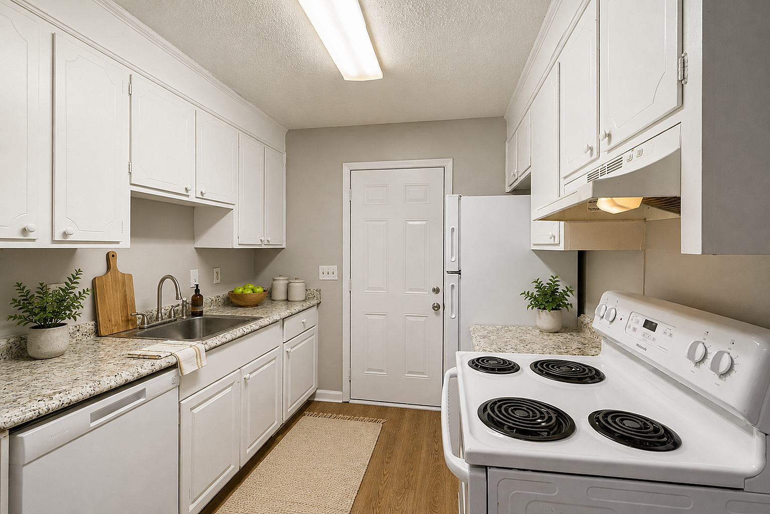 Charming and efficient kitchen with sleek white cabinetry, modern countertops, and cozy ambiance.