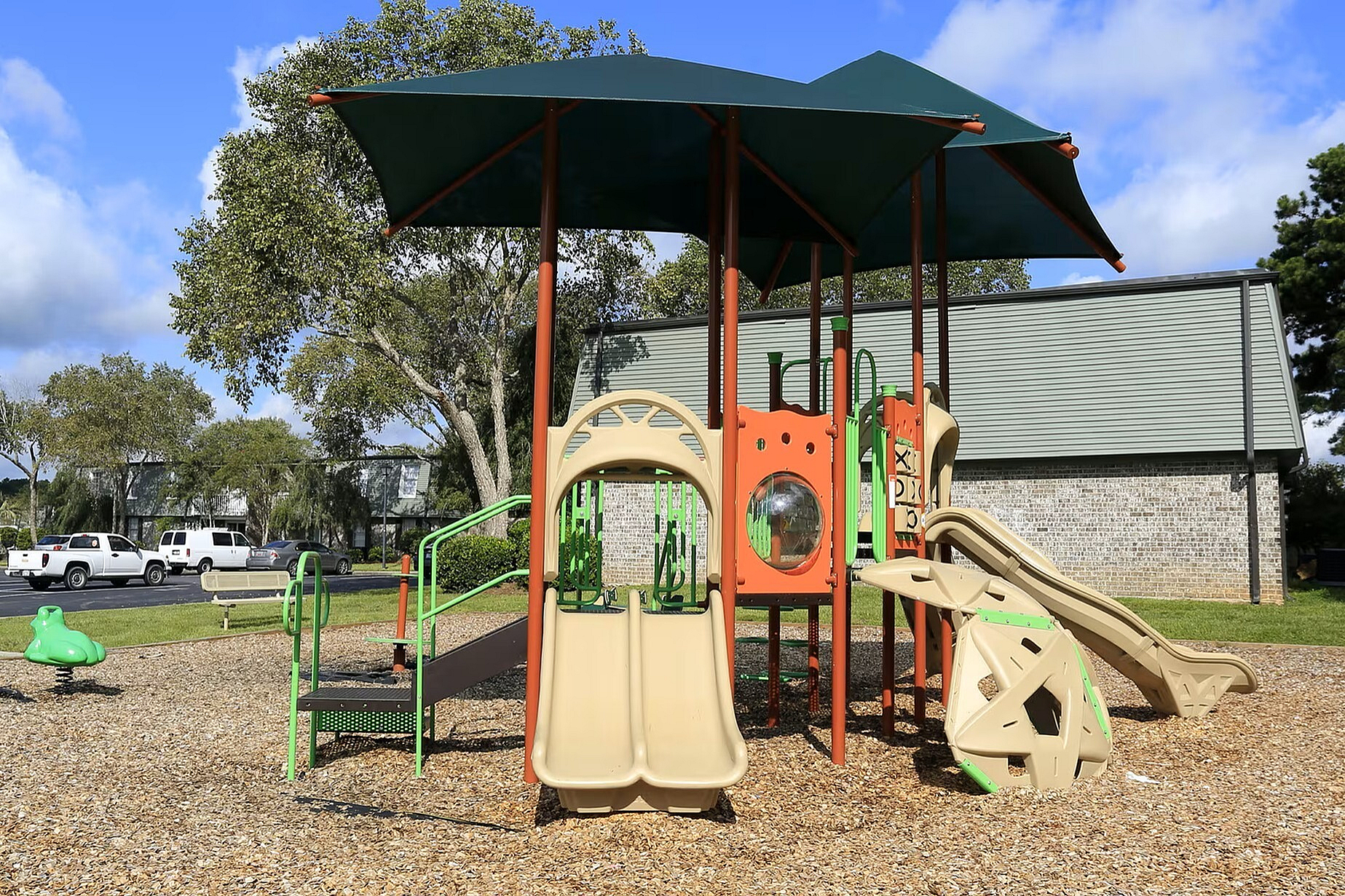 Charming playground with slides and climbing features set in a vibrant community park, perfect for family fun.