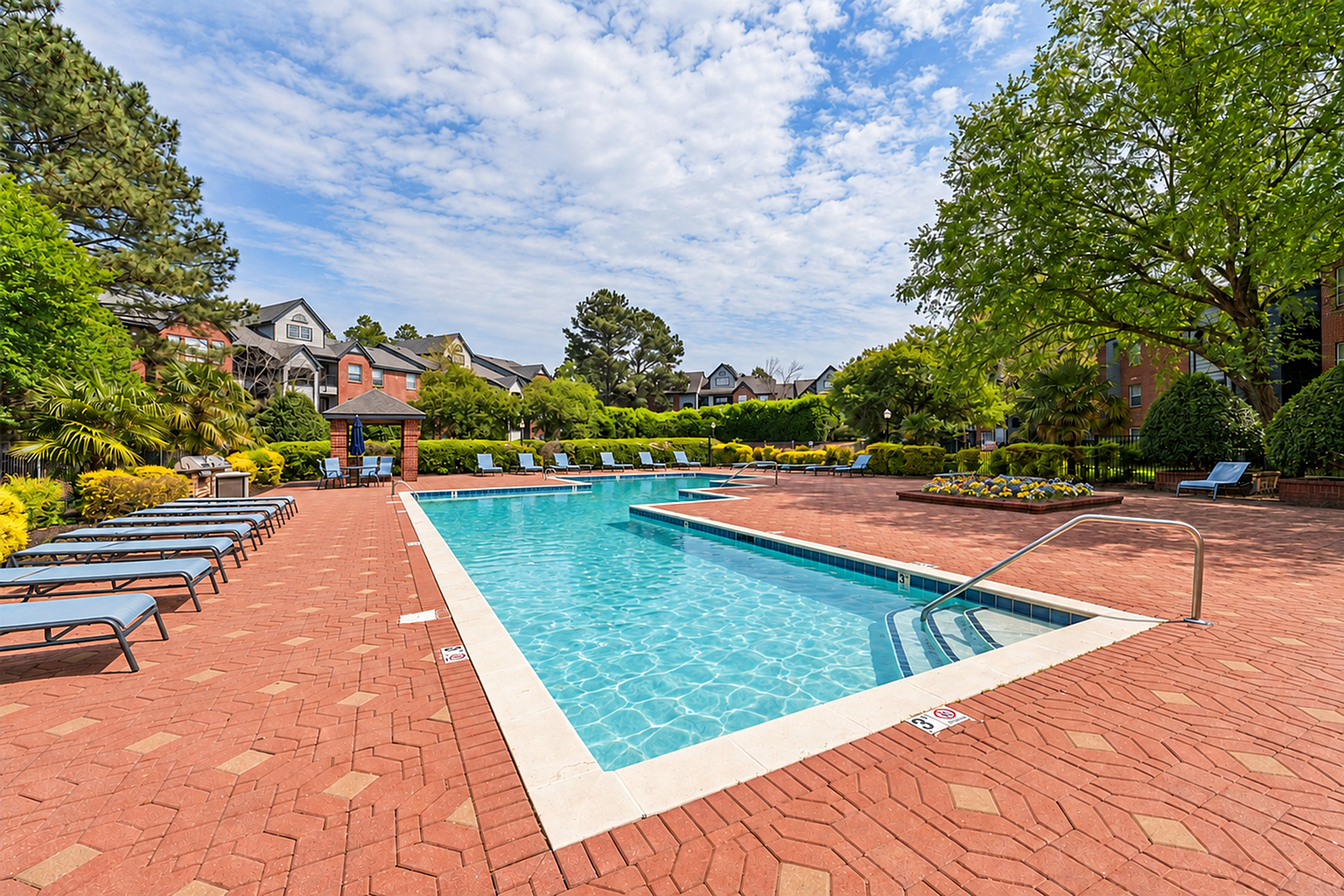 Inviting outdoor pool area with modern lounge chairs, lush landscaping, and a serene ambiance perfect for relaxation.