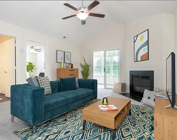 Inviting living room with plush teal sofa, stylish coffee table, modern fireplace, and artistic decor.