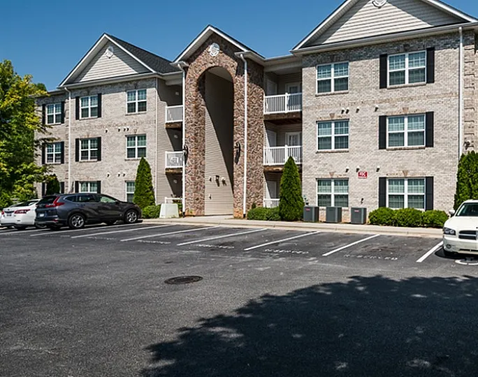 Inviting apartment building with modern architecture and ample parking space.