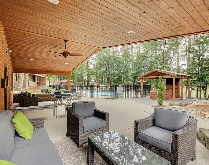 Charming brick apartment building with well-maintained landscaping and balconies under a clear blue sky.