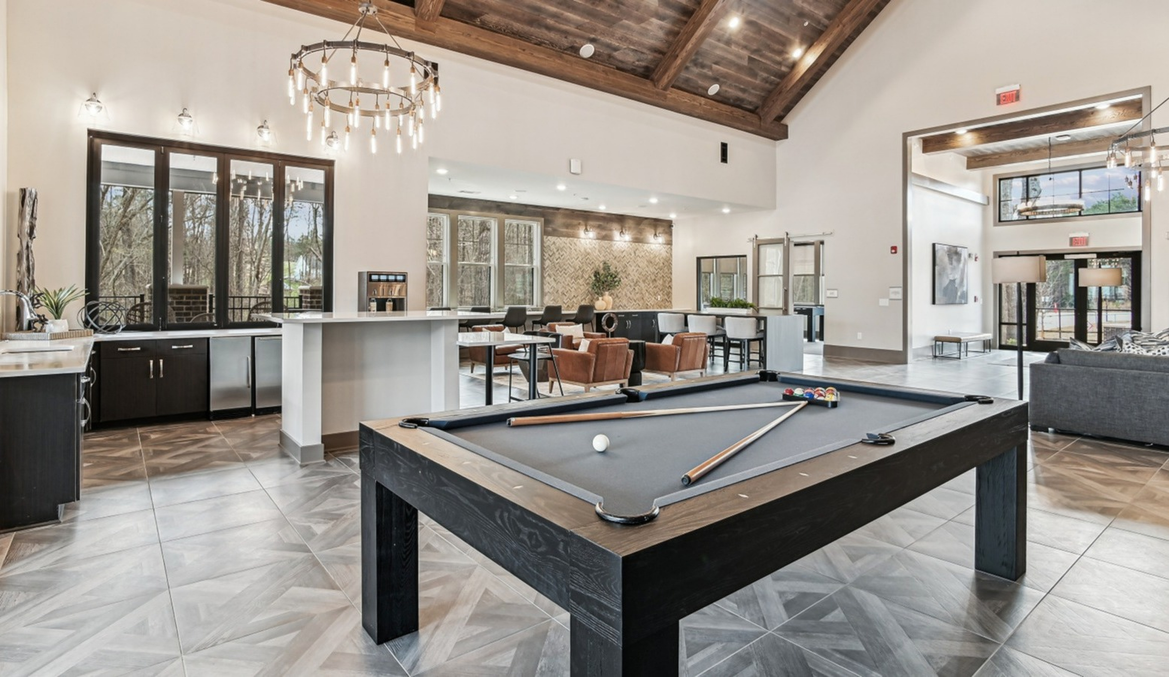 Modern communal lounge with stylish pool table, elegant lighting, and spacious seating area for social gatherings.