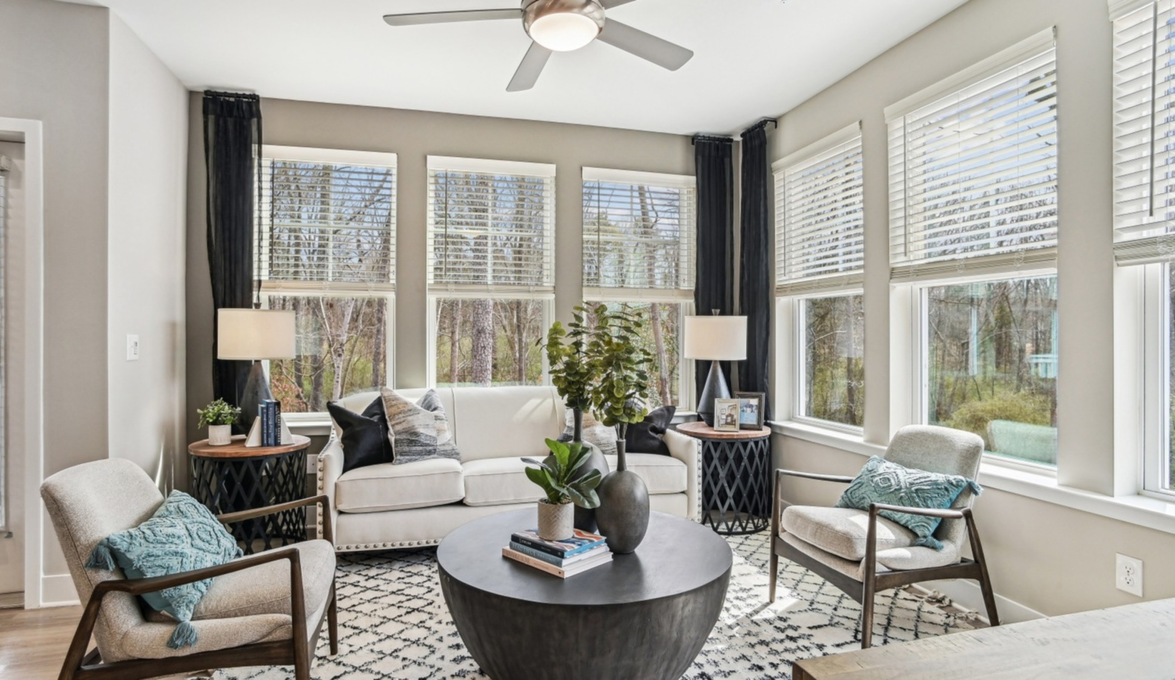 Charming living room with abundant natural light, featuring cozy seating and modern decor.
