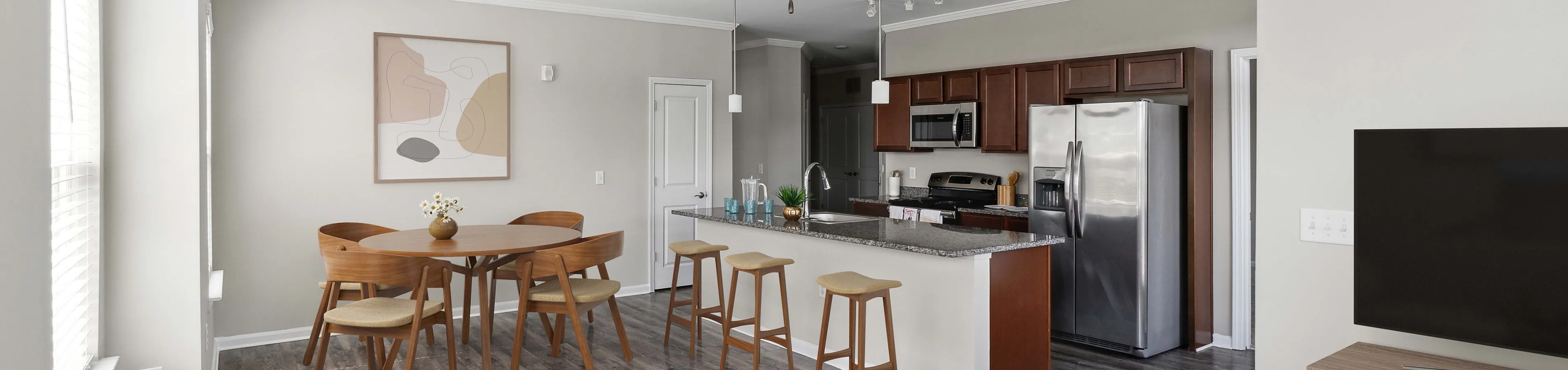 Modern living area featuring open-concept design with stylish kitchen, cozy dining set, and a sleek ceiling fan.