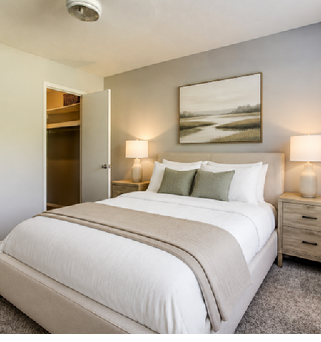 Inviting bedroom with plush carpet, elegant gray wall accents, and cozy ambient lighting.