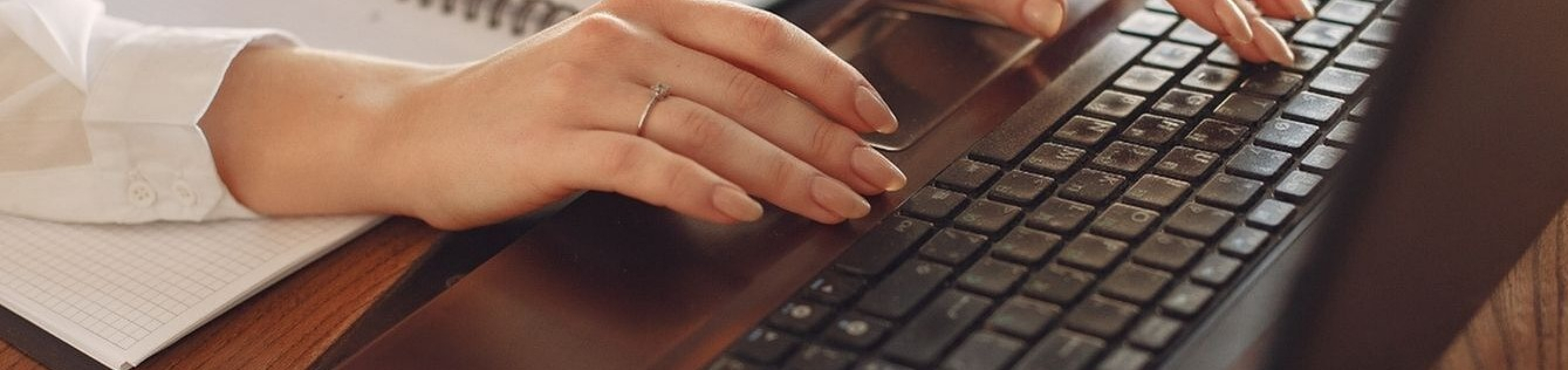 Close-up of hands efficiently typing on a sleek laptop keyboard, highlighting modern technology and productivity.