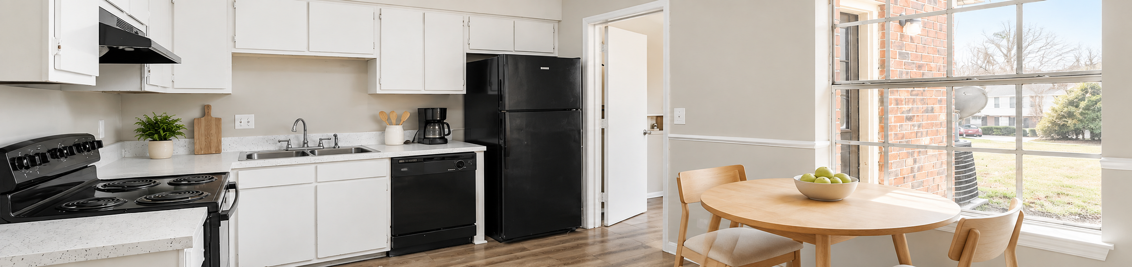 Charming kitchen with modern appliances, cozy dining area, and bright natural light from large window.