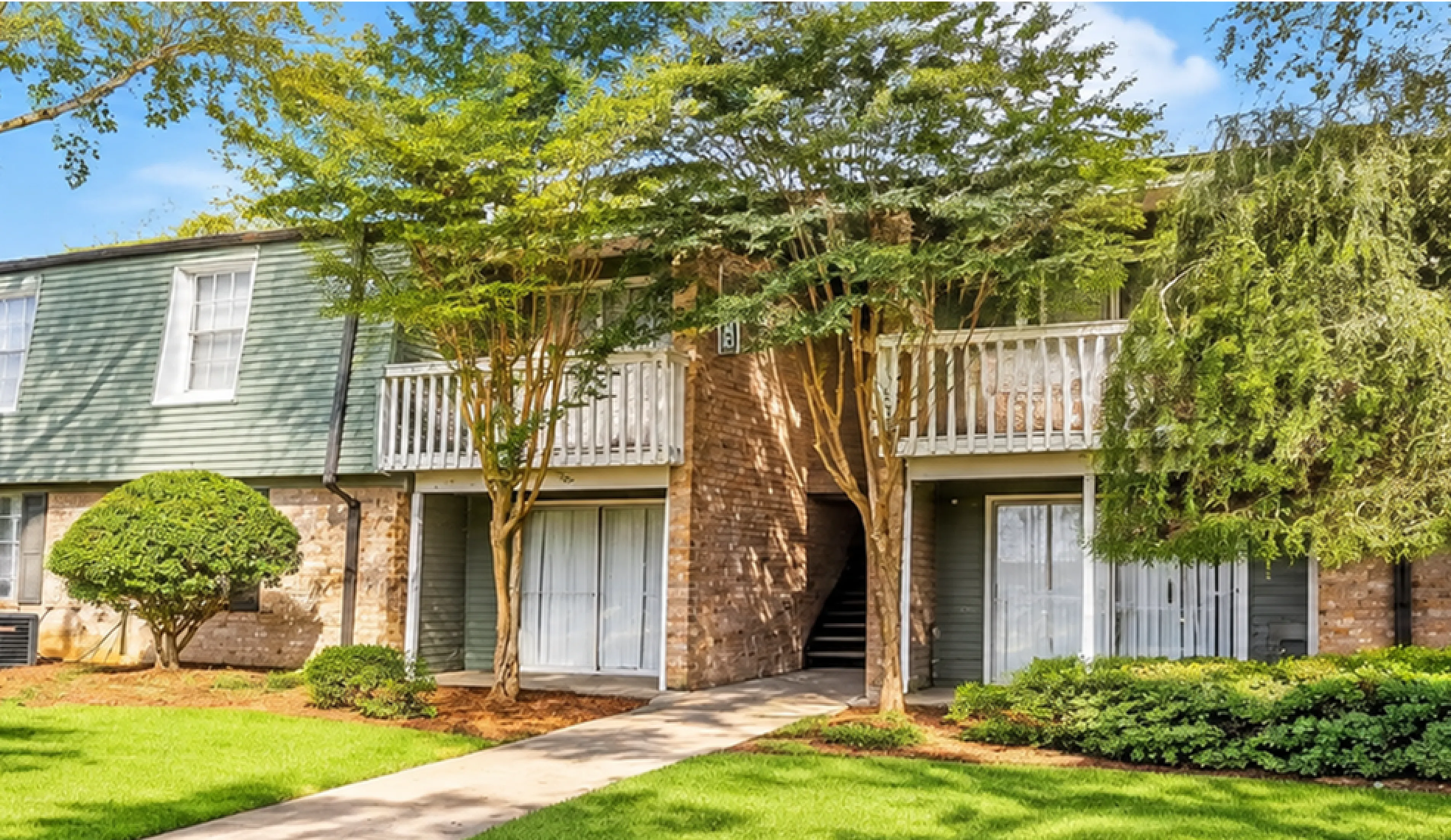 Charming apartment complex with lush green landscaping and inviting pathways, ideal for modern living.