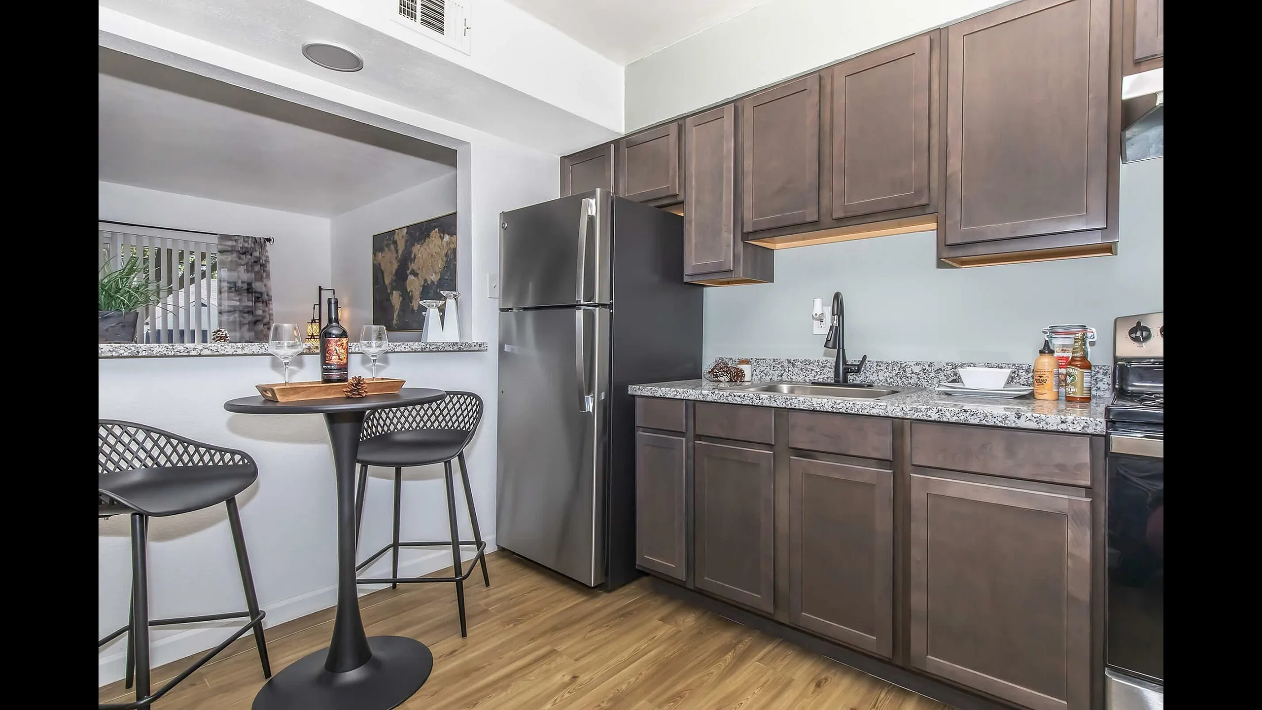 Inviting kitchen space with dark cabinetry, sleek countertops, and a cozy breakfast bar with stylish seating.