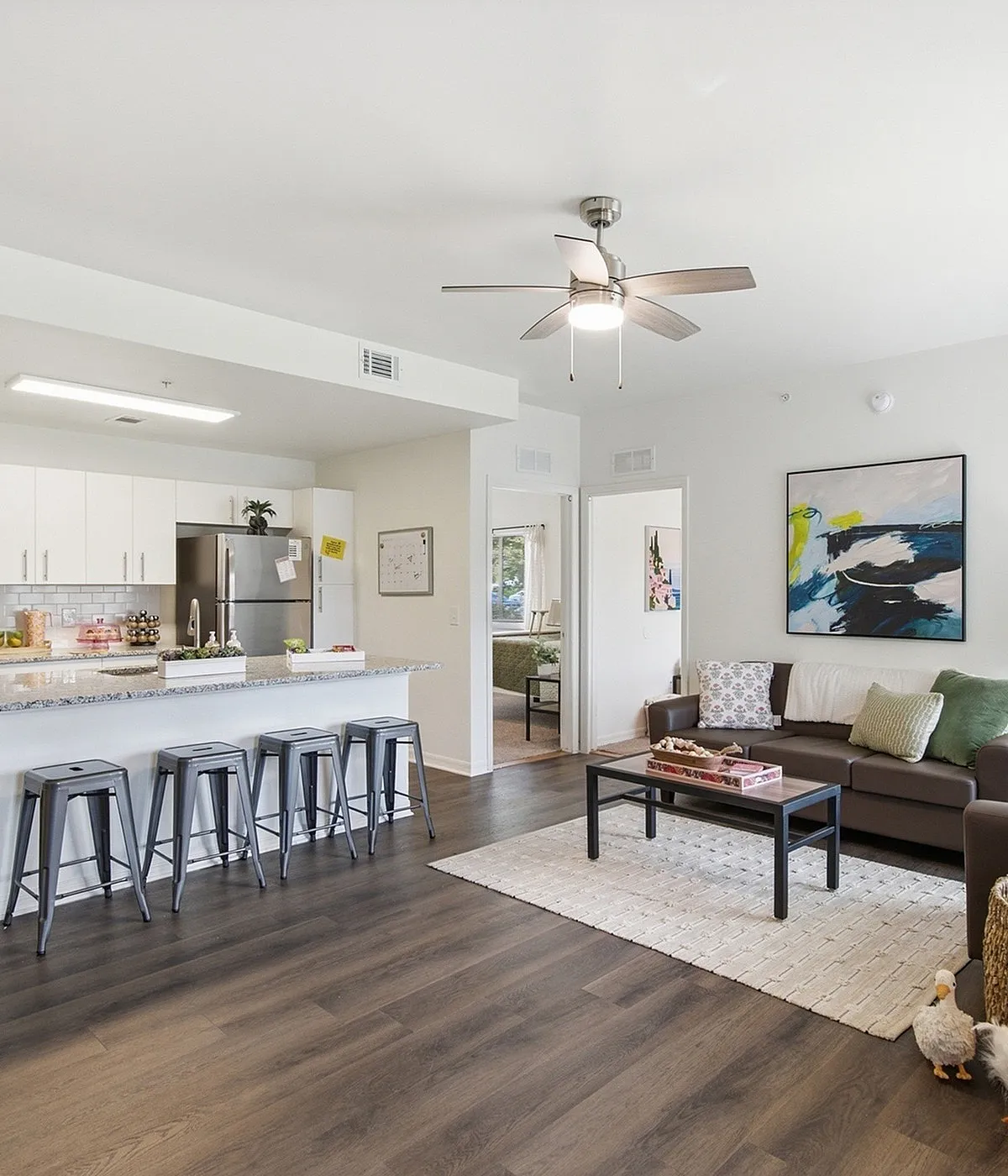 Bright open-concept kitchen and living area with modern appliances, sleek countertops, and cozy seating, ideal for comfortable living.