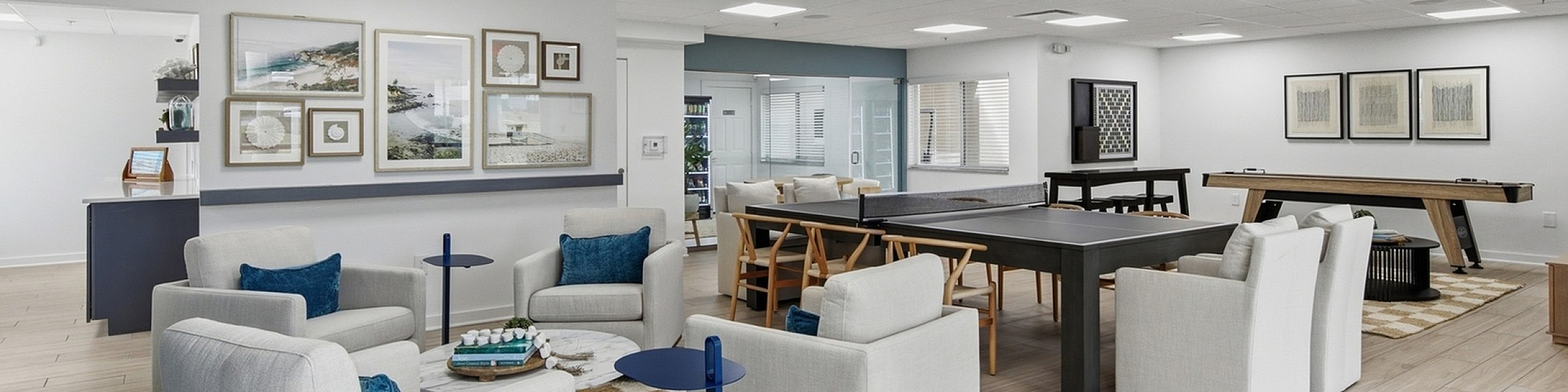 Elegant communal lounge featuring modern seating, a pool table, and decor with stylish artwork for relaxation and entertainment.