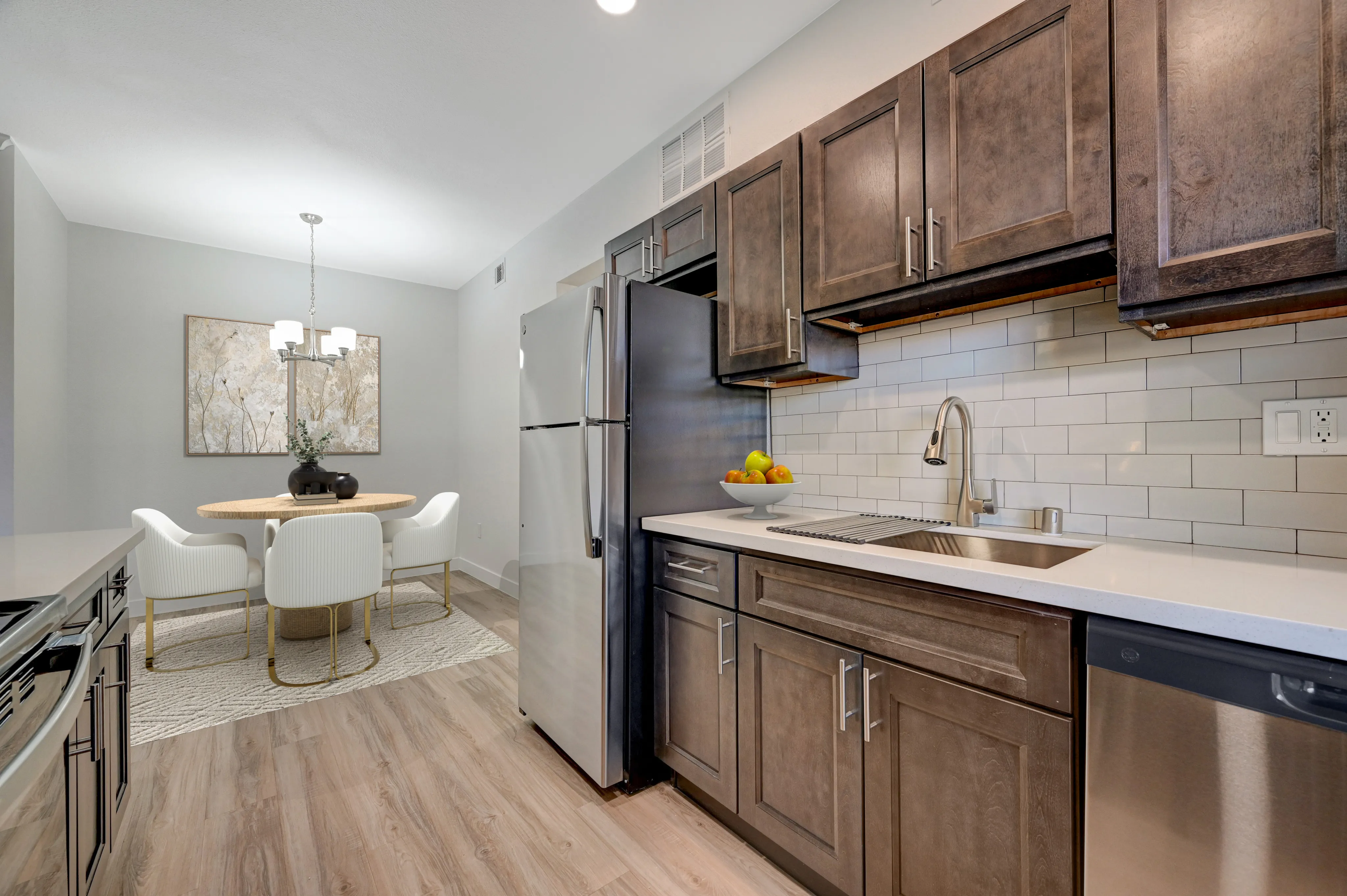 Modern kitchen with sleek cabinetry, stainless steel appliances, and a chic dining area with elegant decor.