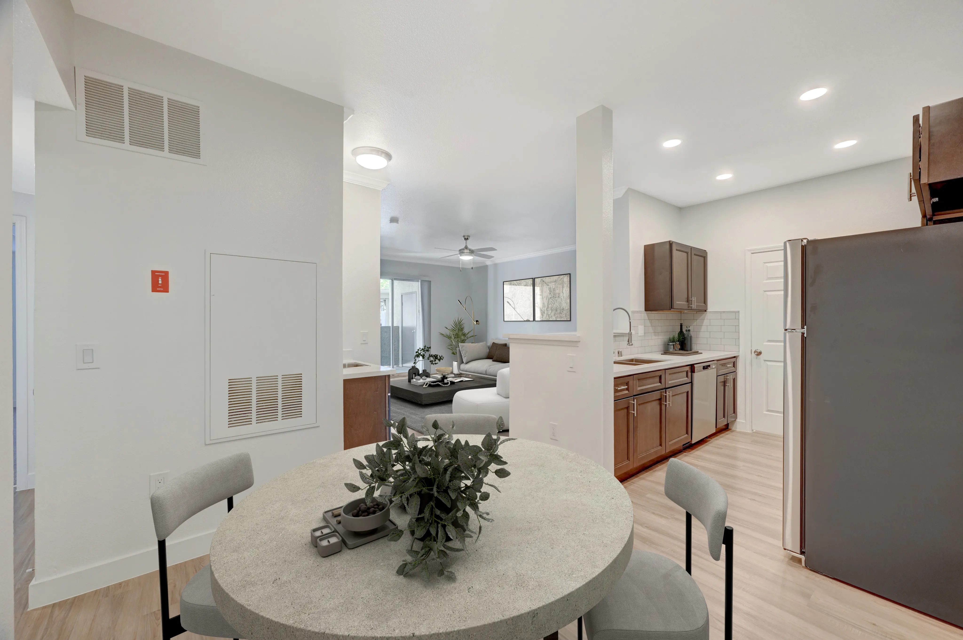 Modern open-concept living space featuring a cozy living room, sleek kitchen with dark wood cabinets, and stylish dining area.