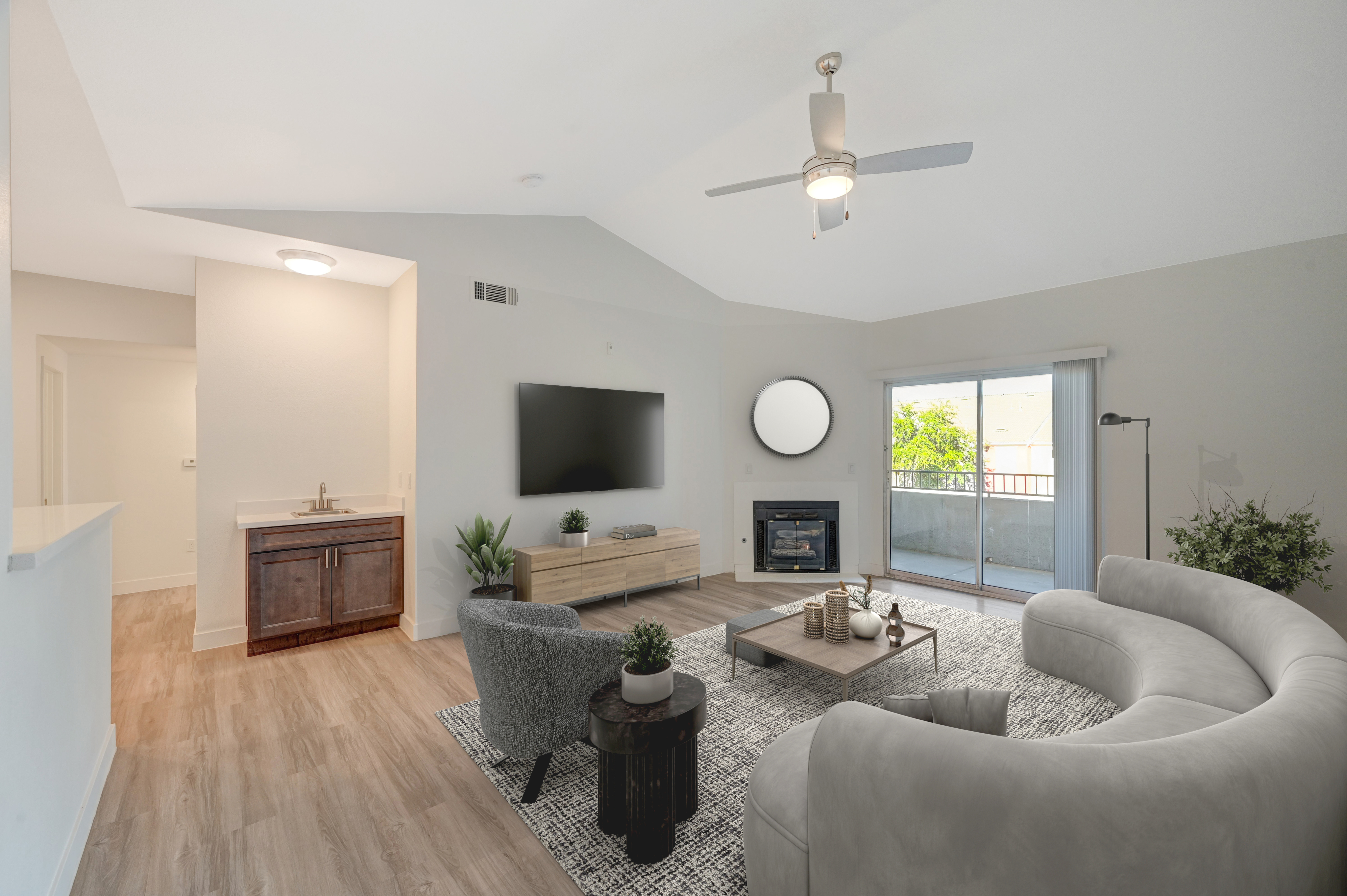 Bright and airy living room with modern decor, sliding glass door leading to balcony, and sleek hardwood flooring.