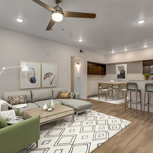 Inviting open-concept living space with modern decor, featuring a cozy seating area, stylish wooden floors, and a breakfast bar adjacent to the kitchen.