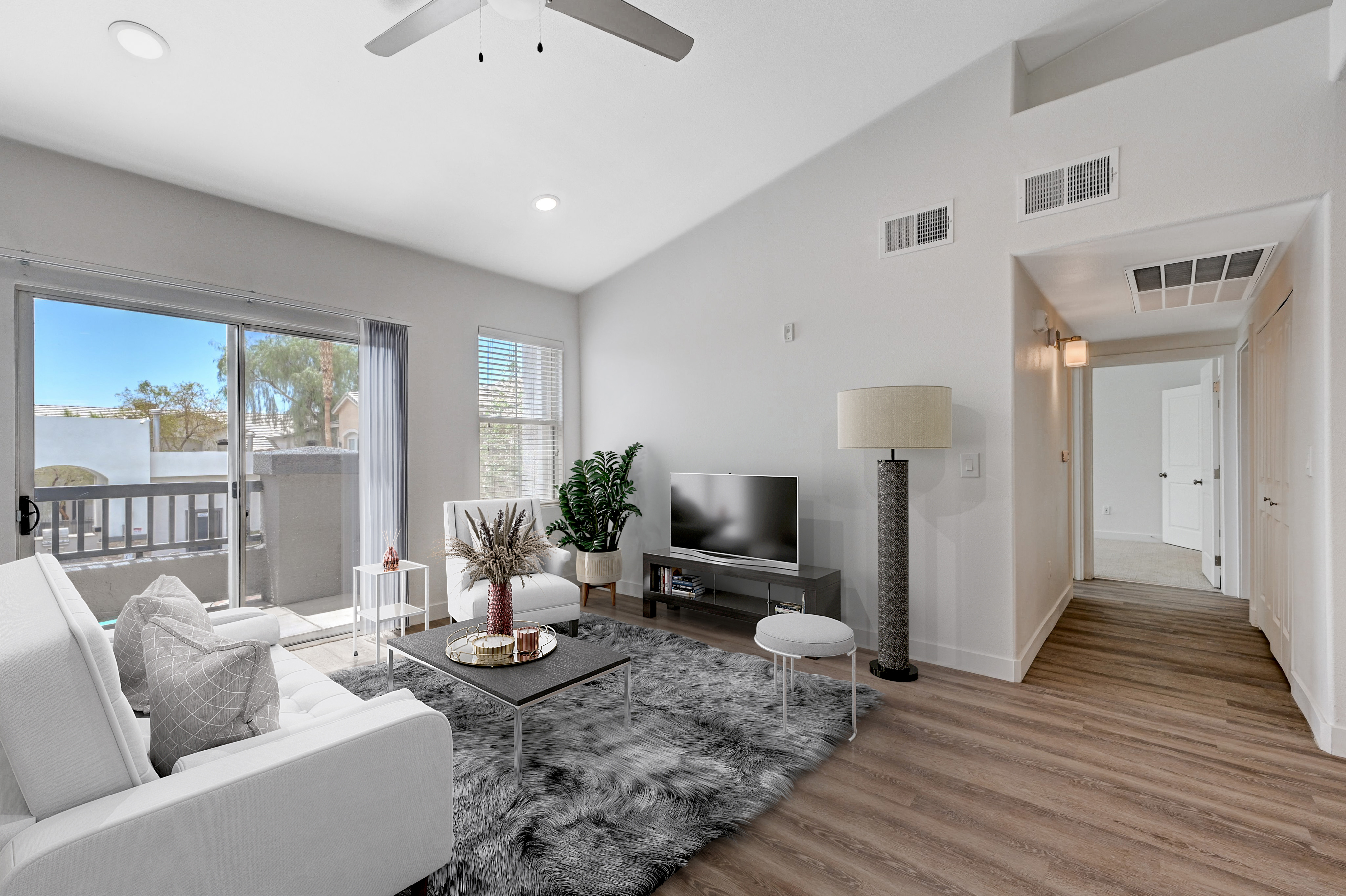 Bright and airy living room with modern decor, featuring a cozy sofa, elegant furnishings, and large sliding glass doors opening to a sunny balcony.