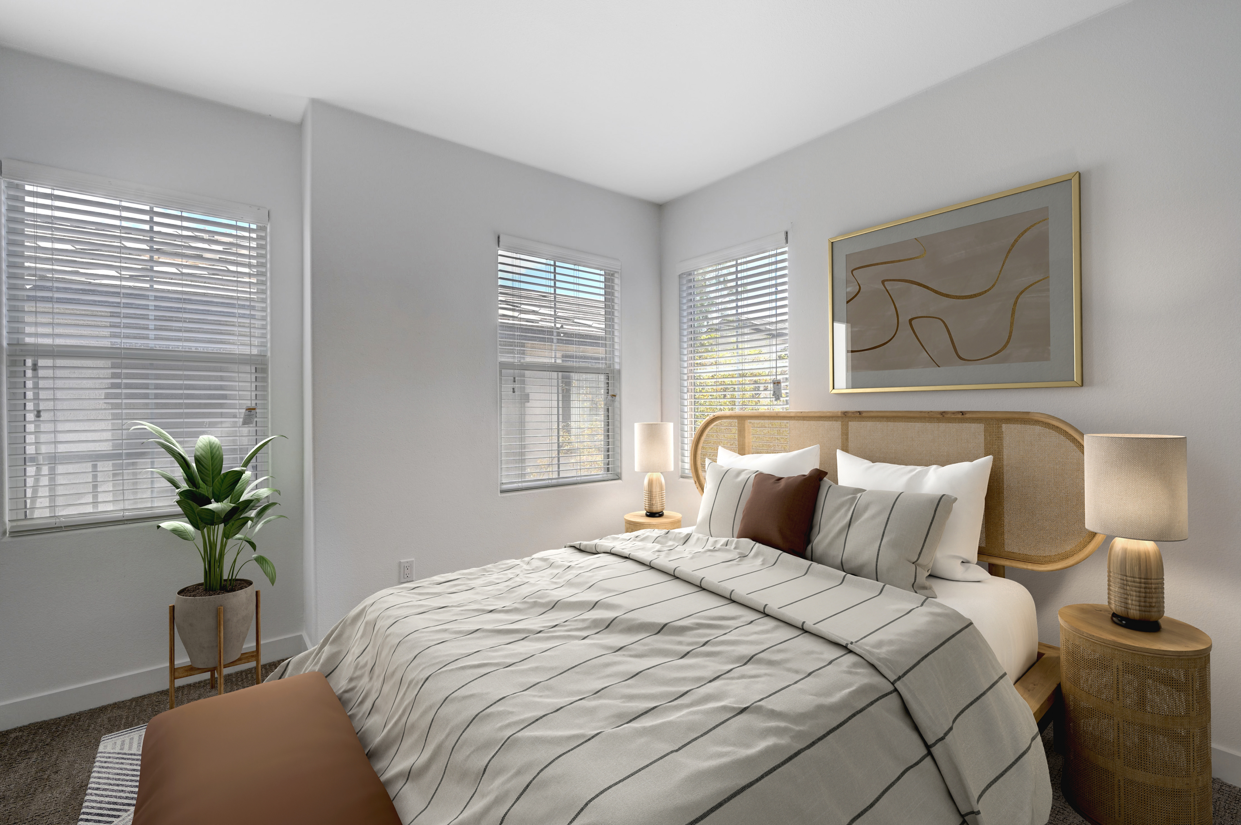 Bright and modern bedroom featuring a chic framed artwork, stylish bedding, and abundant natural light through wide windows.