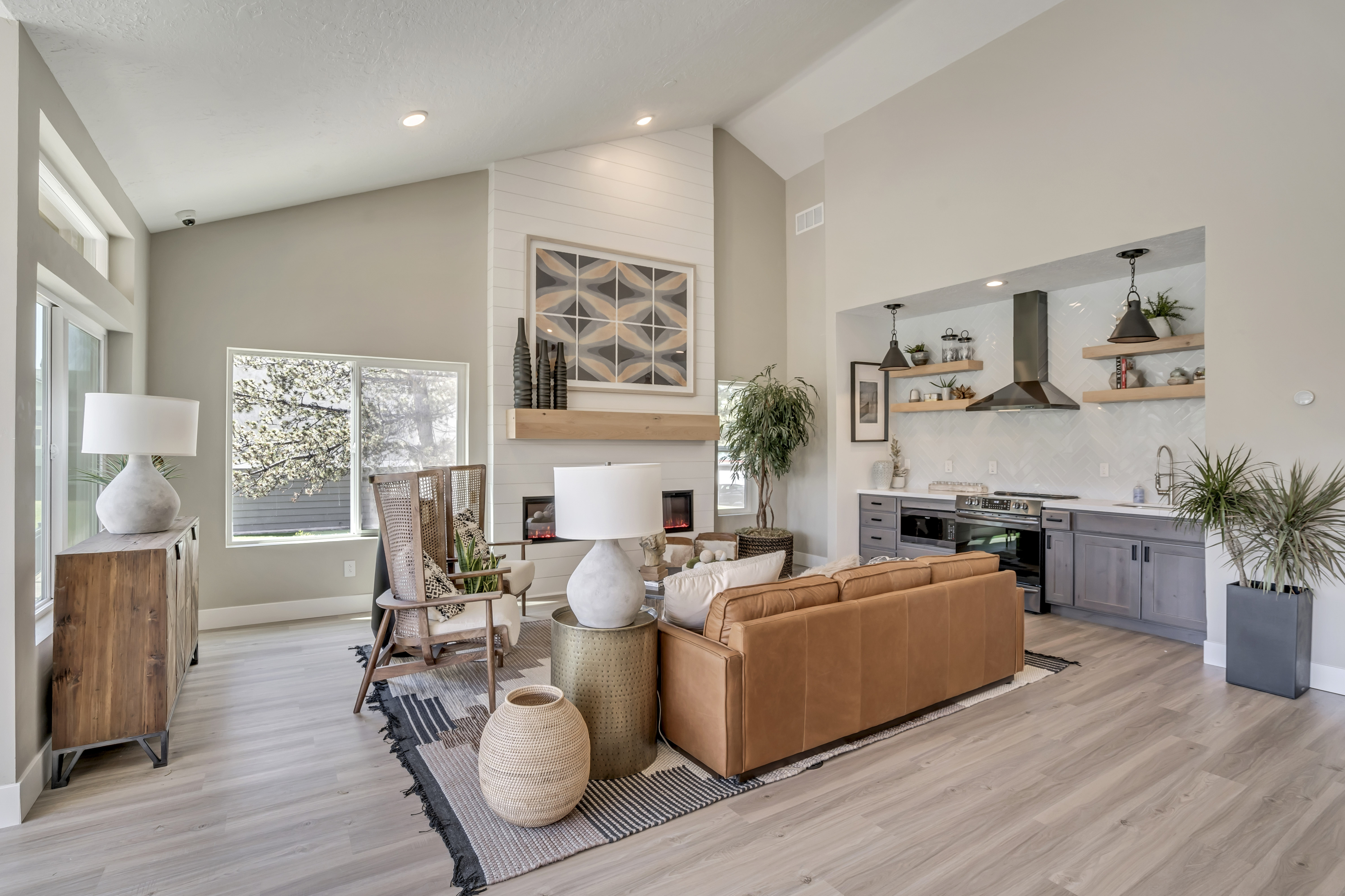 Inviting open-concept living room with cozy fireplace, modern kitchen, and stylish decor, perfect for relaxation and entertaining.