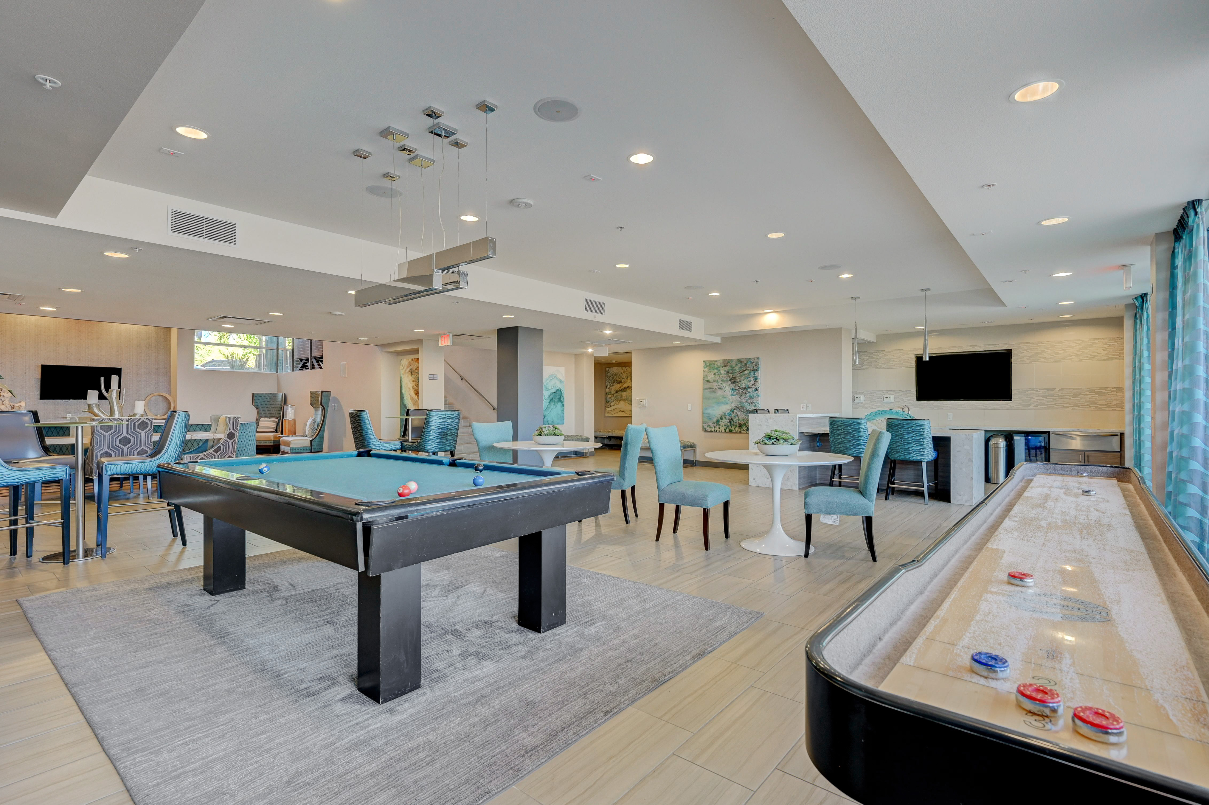Modern recreational lounge featuring a sleek pool table, stylish seating areas, and vibrant decor for ultimate relaxation.