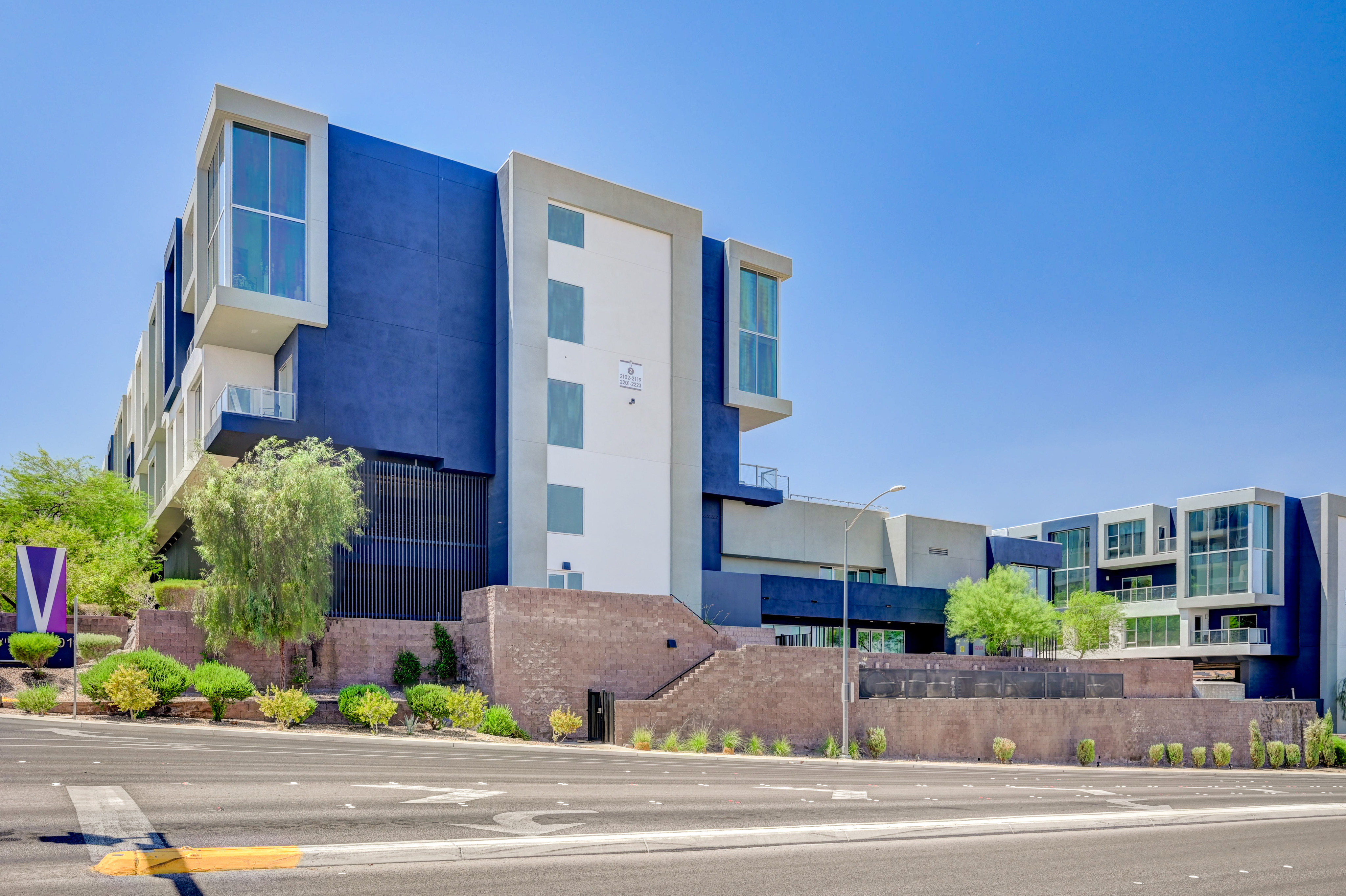 Modern apartment building with striking geometric architecture, featuring large windows and sleek design elements.