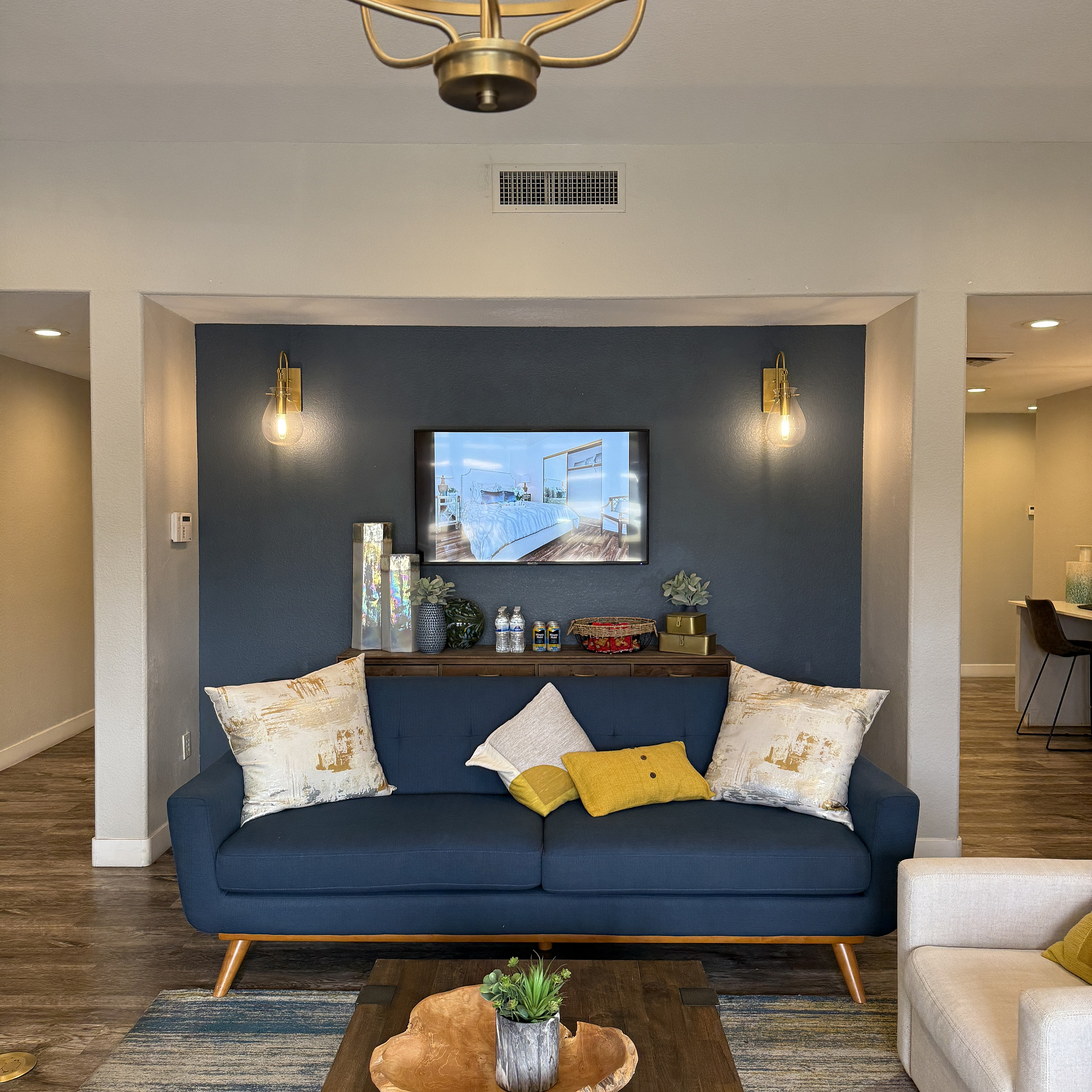 Contemporary living room with chic blue sofa, stylish lighting, and cozy decor for modern comfort.