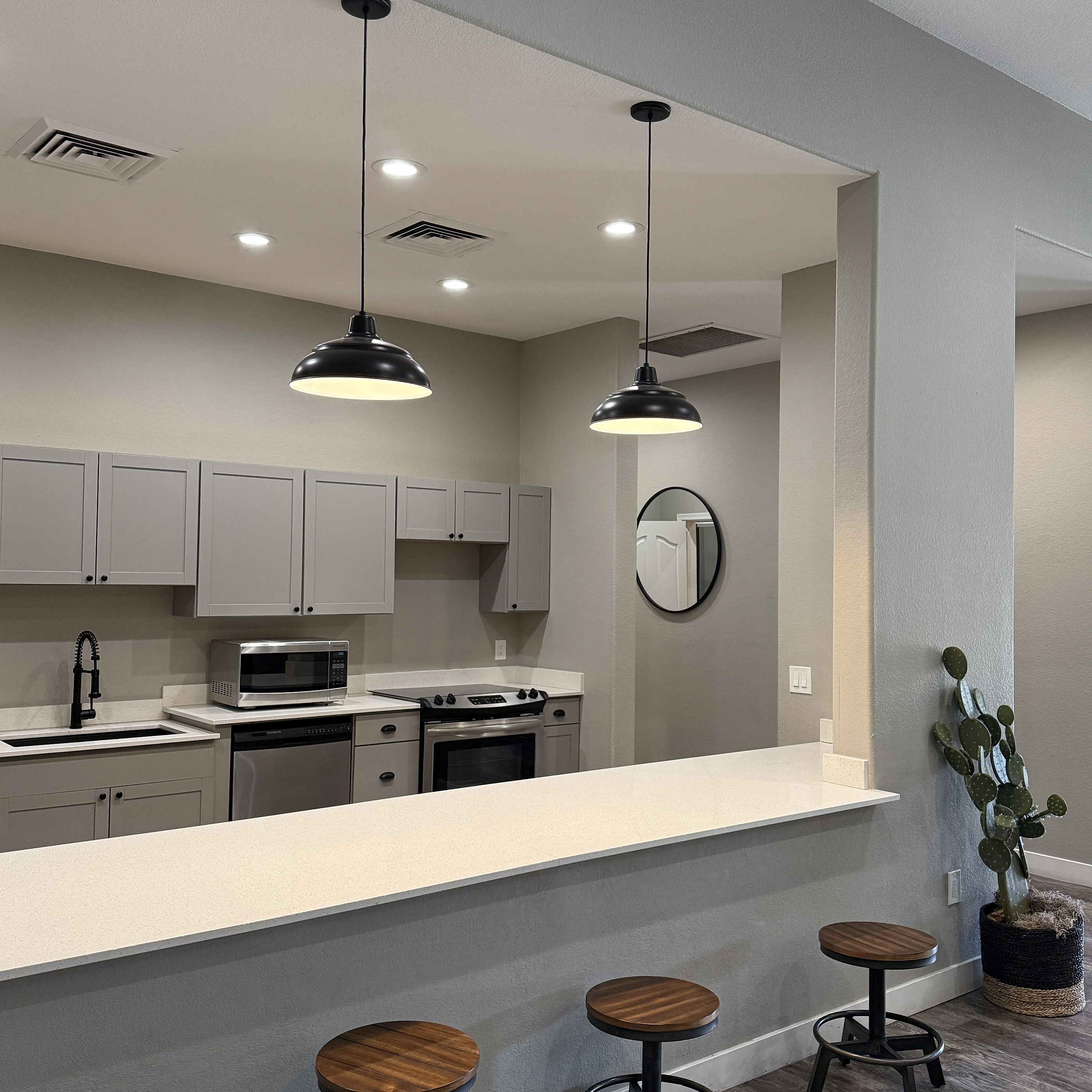 Contemporary kitchen with elegant pendant lighting, sleek countertops, and stylish bar stools.