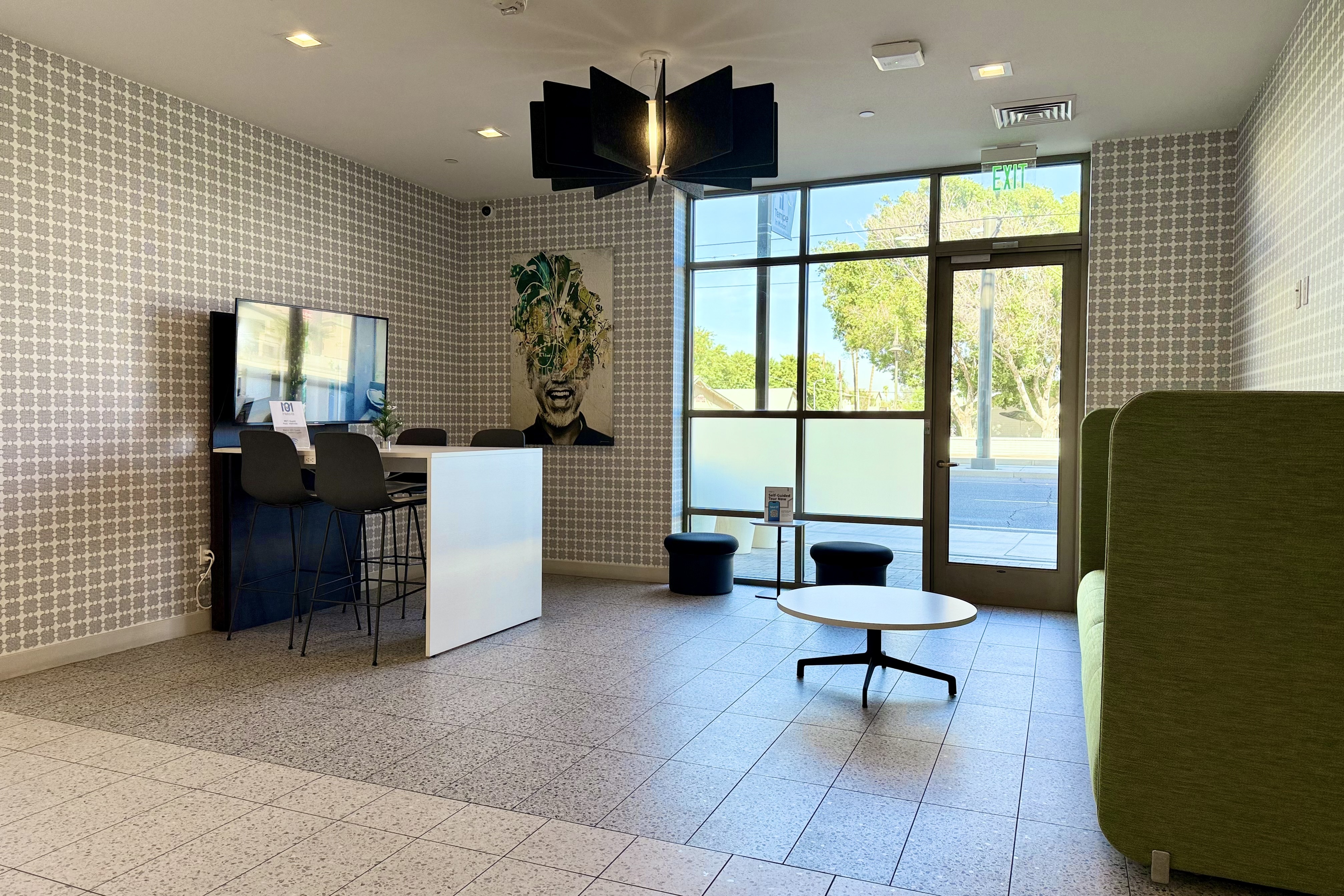Chic and modern apartment lobby with stylish seating, contemporary lighting, large windows, and artistic decor.
