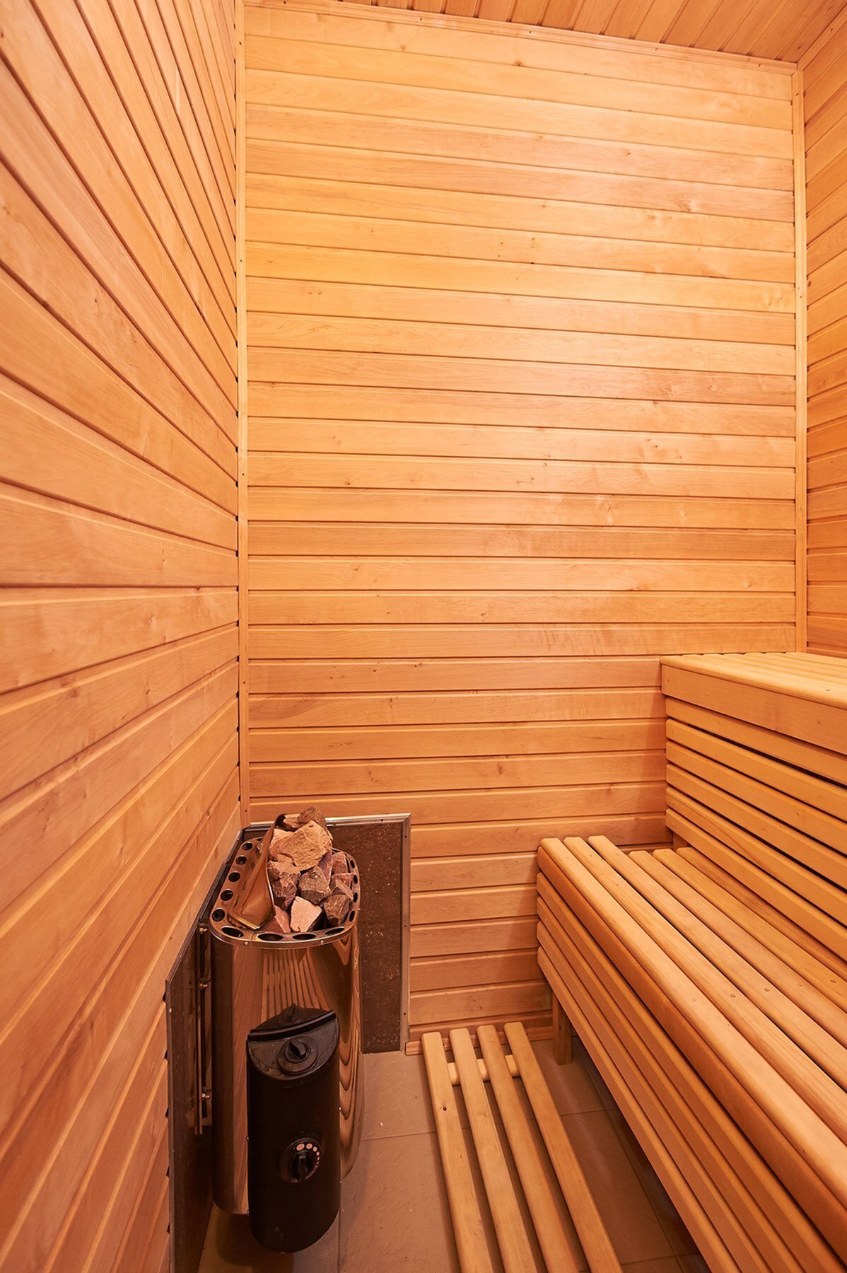 Luxurious wooden sauna featuring elegant bench seating and a modern heater for ultimate relaxation.