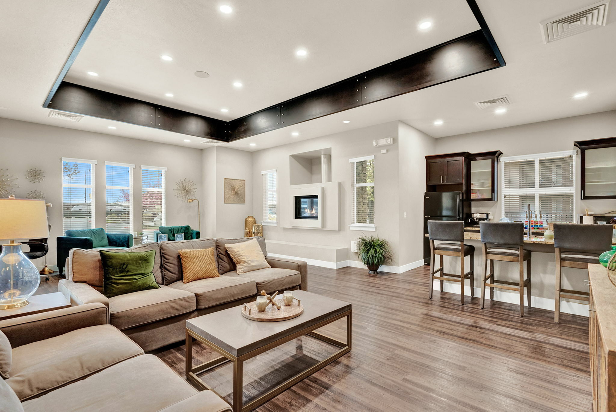 Inviting open-concept living room with elegant decor, plush seating, and a modern kitchen with bar seating, perfect for entertaining.