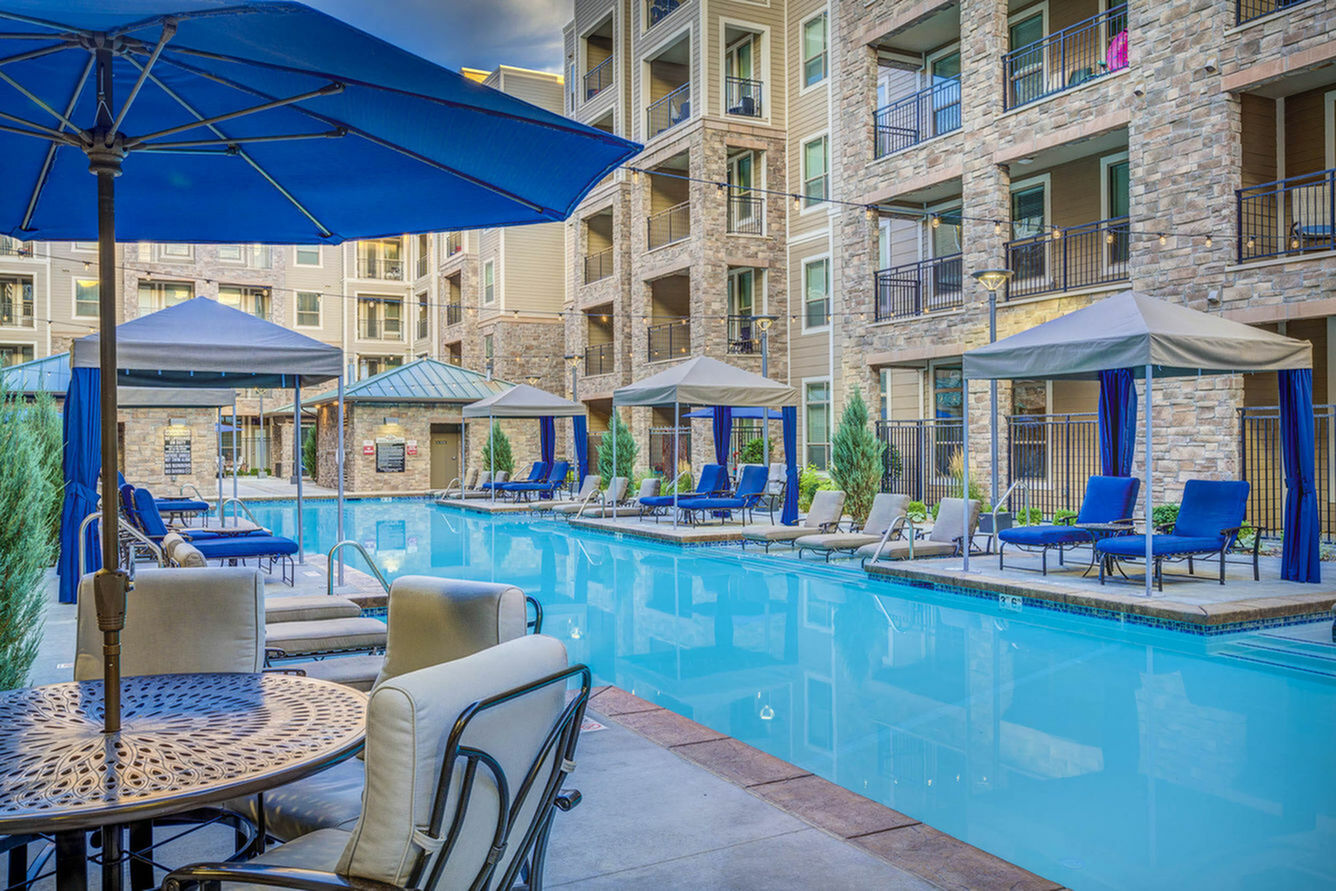 Luxurious apartment complex with elegant poolside seating, cabanas, and stylish architecture.