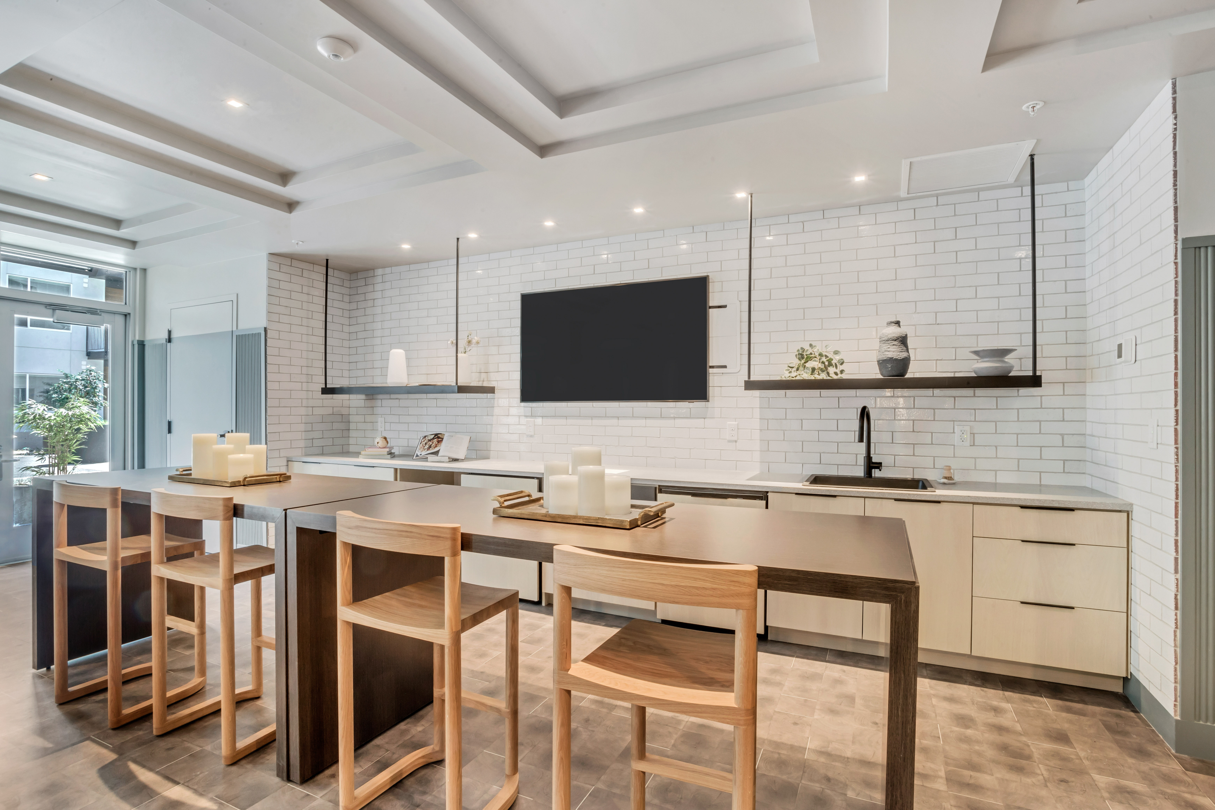 Chic modern kitchen featuring sleek countertops, elegant bar seating, and a bright, airy atmosphere.