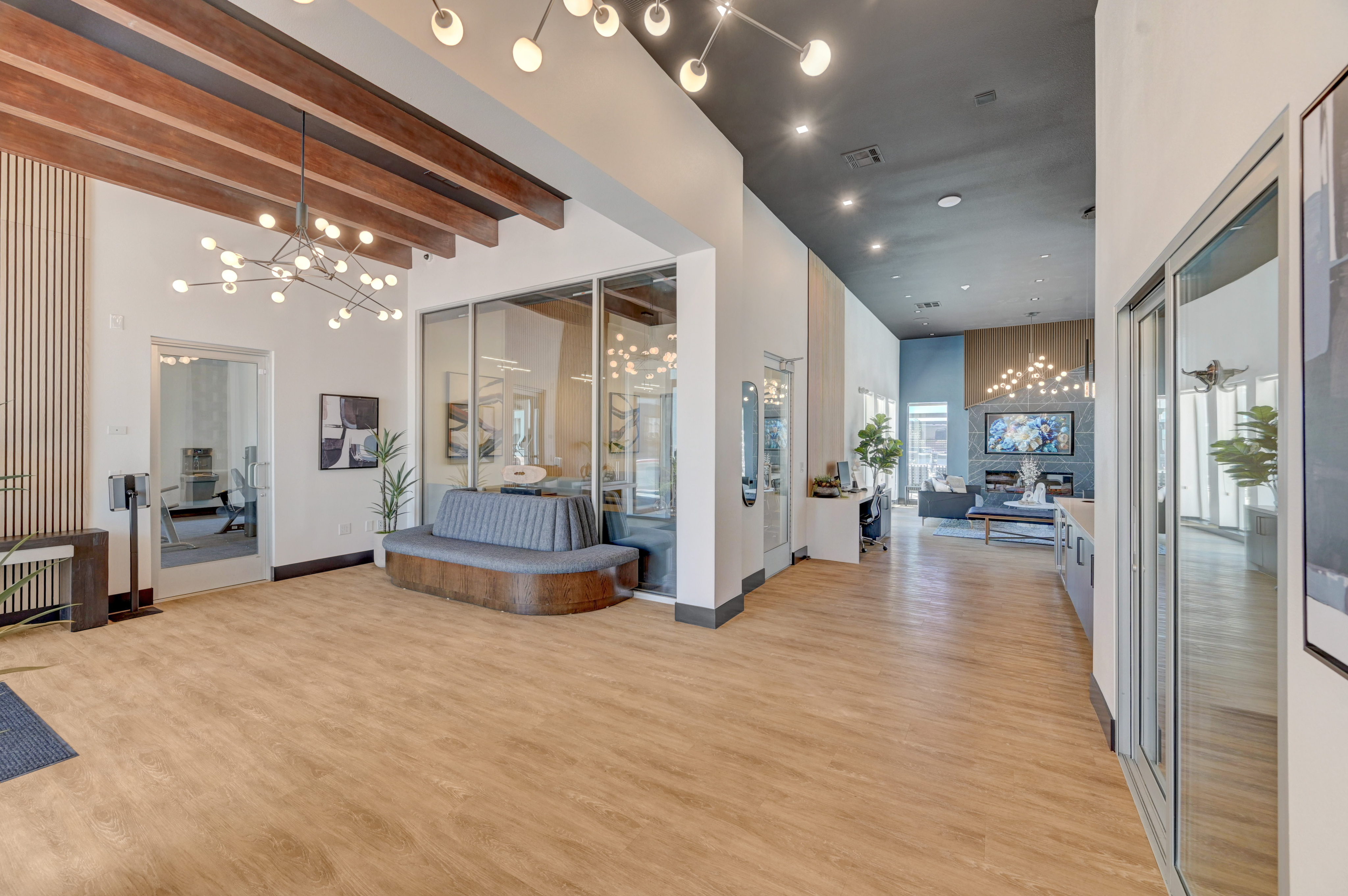 Elegant contemporary apartment lobby with modern lighting, stylish wood flooring, and a cozy seating area.