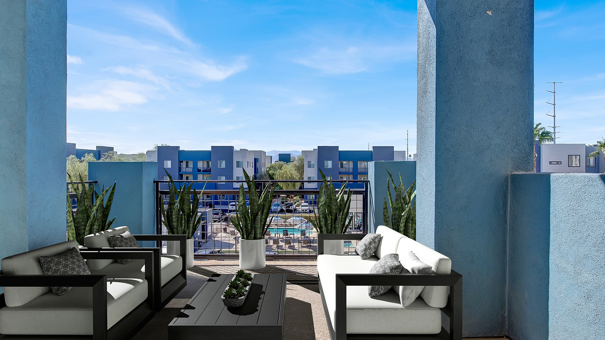 Chic balcony view showcasing modern outdoor seating with vibrant blue architecture backdrop, lush plants, and bright skies.