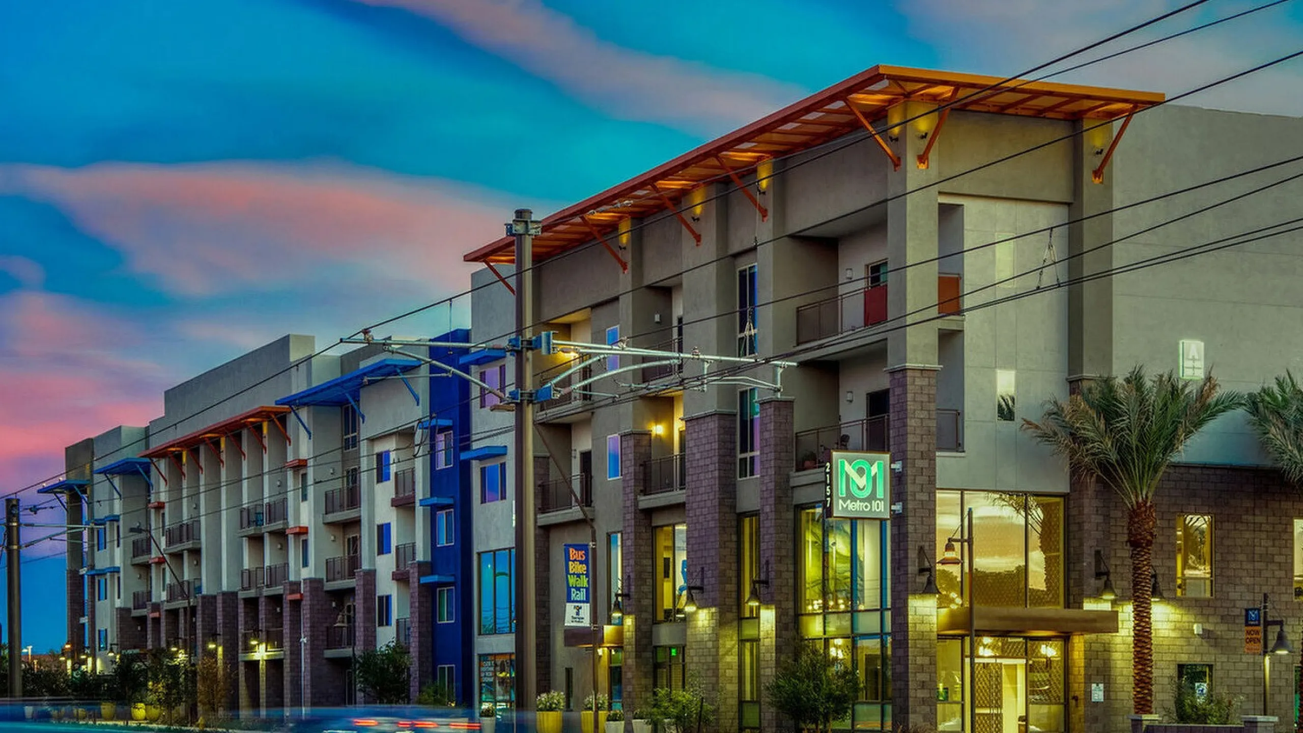 Chic urban apartment complex exterior with modern design and vibrant evening skies.