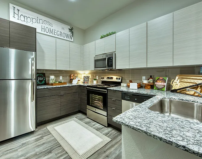 Modern kitchen with sleek appliances, granite countertops, and stylish cabinetry, elegantly decorated with a 'Happiness is Homegrown' sign.