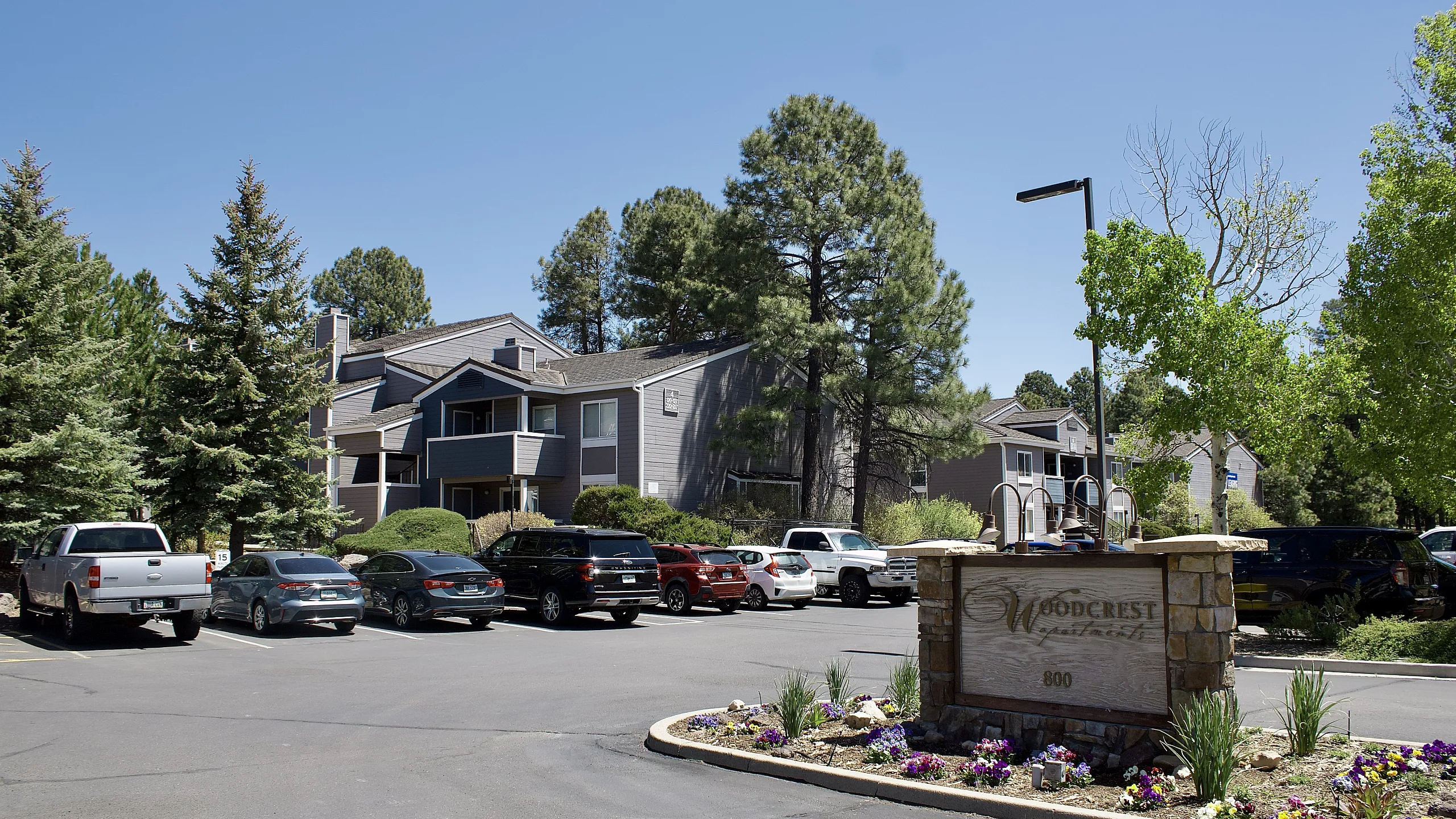 Charming apartment complex surrounded by lush greenery and ample parking, offering serene and comfortable living.