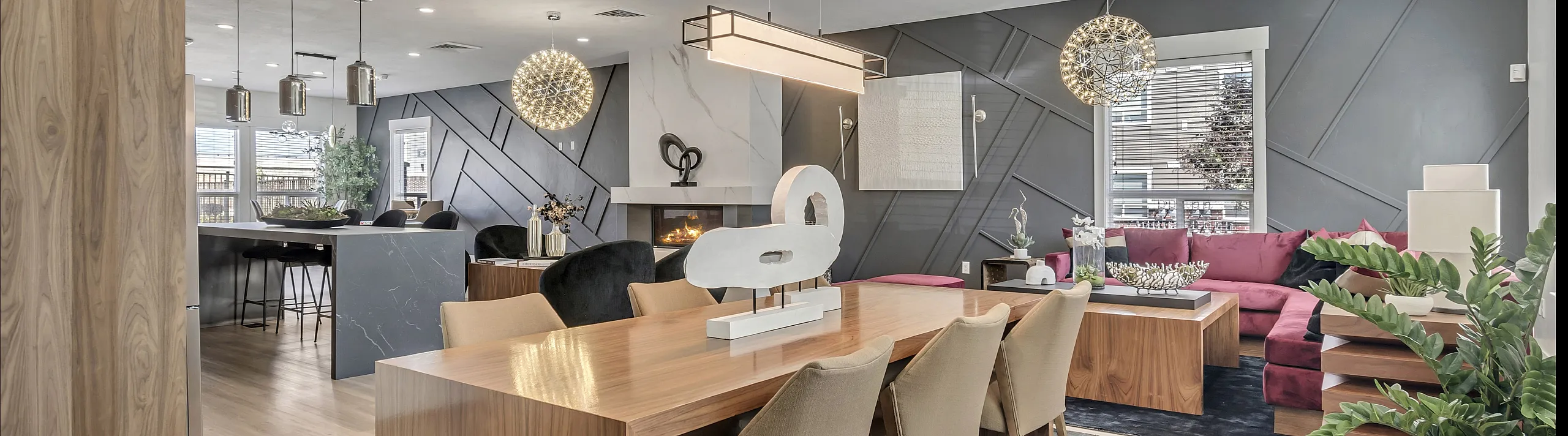 Modern open-concept living and dining area featuring sleek wood finishes, elegant pendant lighting, and a cozy fireplace, perfect for stylish entertaining.
