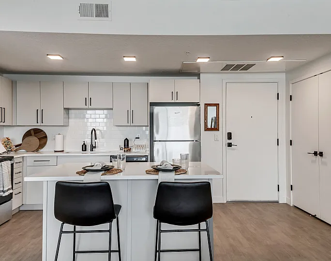 Modern kitchen with sleek cabinetry, a spacious island with seating, and stainless steel appliances, perfect for entertaining.