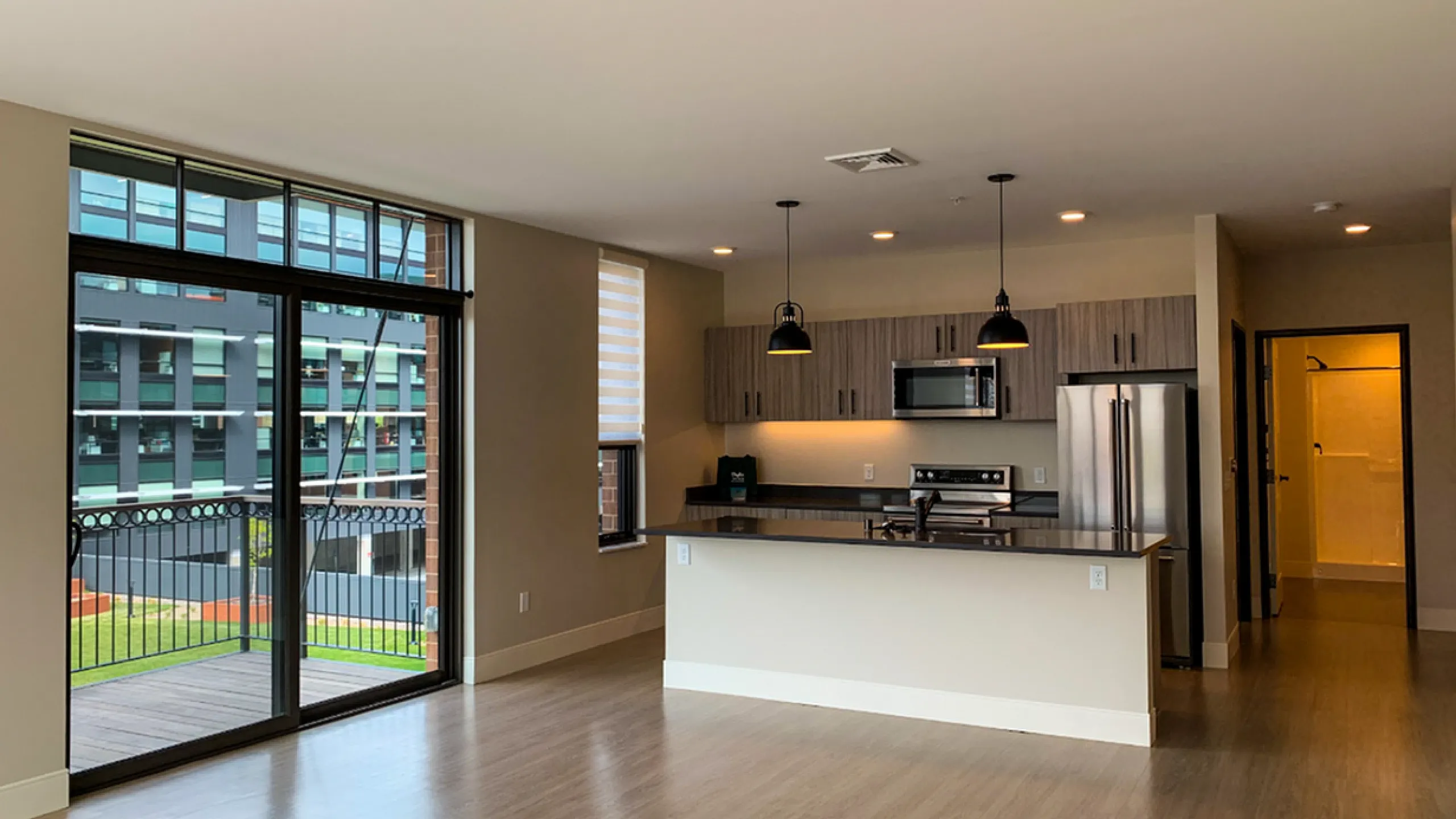 Bright and modern living area with open-concept kitchen and large balcony windows.