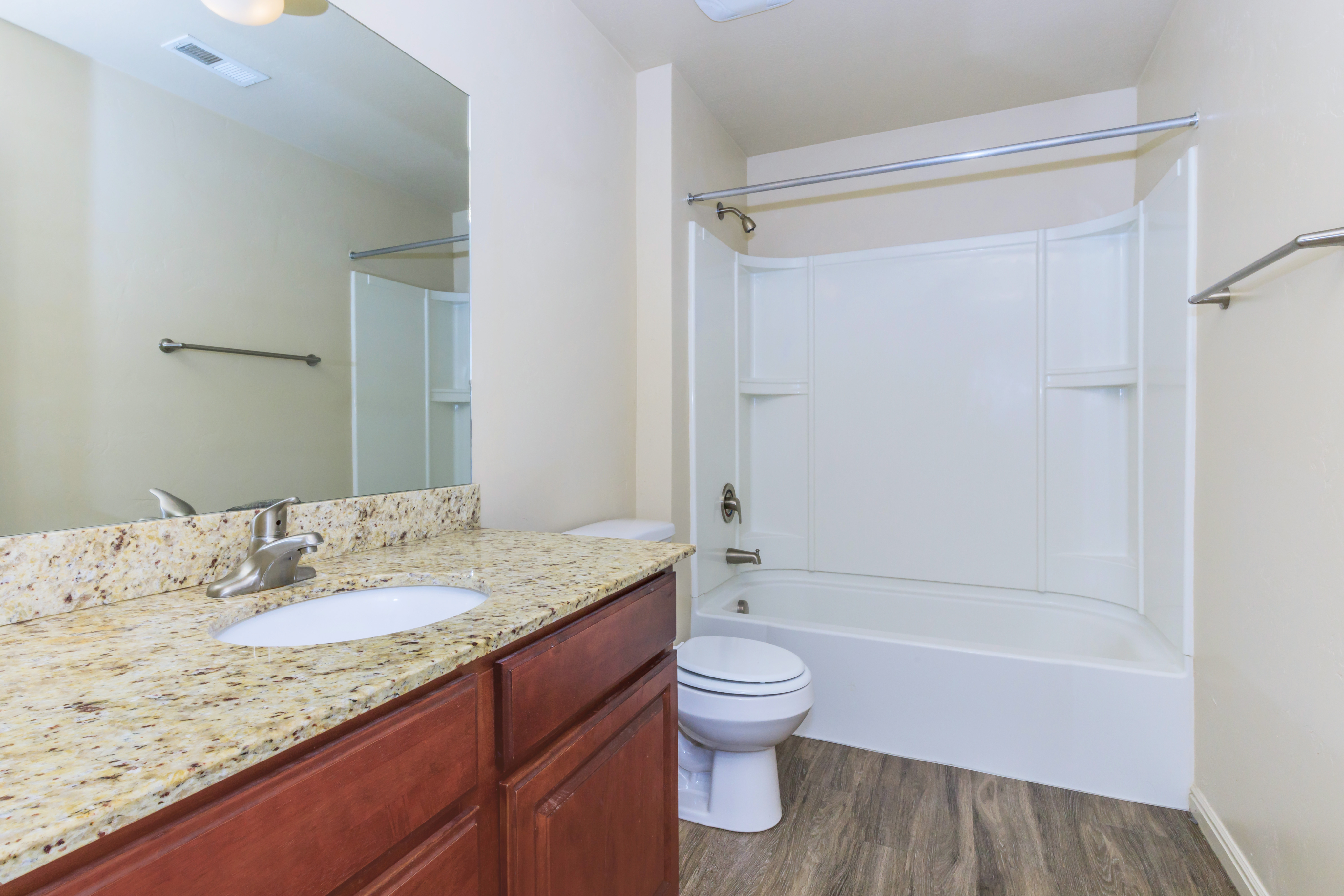 Elegant bathroom featuring granite countertops, sleek vanity, and pristine bathtub, perfect for relaxation.