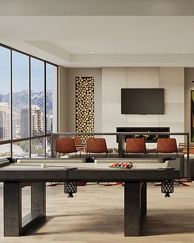 Modern apartment interior with a spacious open concept living area, kitchen, and pool table, offering stunning city skyline and mountain views.