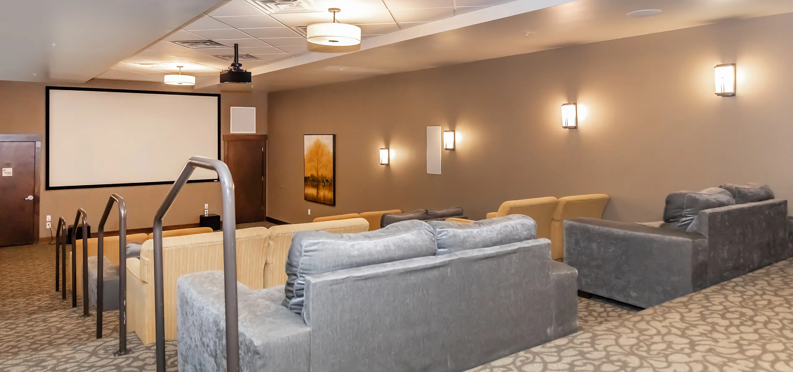Luxurious home theater room with plush seating, state-of-the-art projection screen, and ambient lighting for an ultimate cinematic experience.