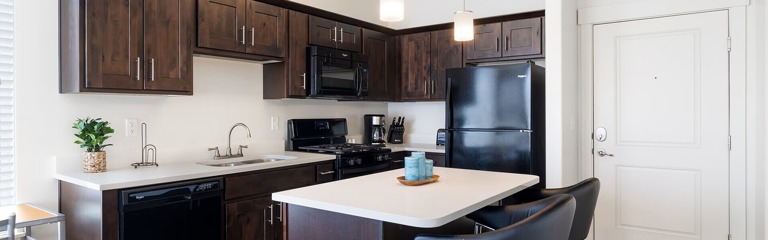 Chic modern kitchen with dark wood cabinets, sleek appliances, and cozy breakfast bar seating.